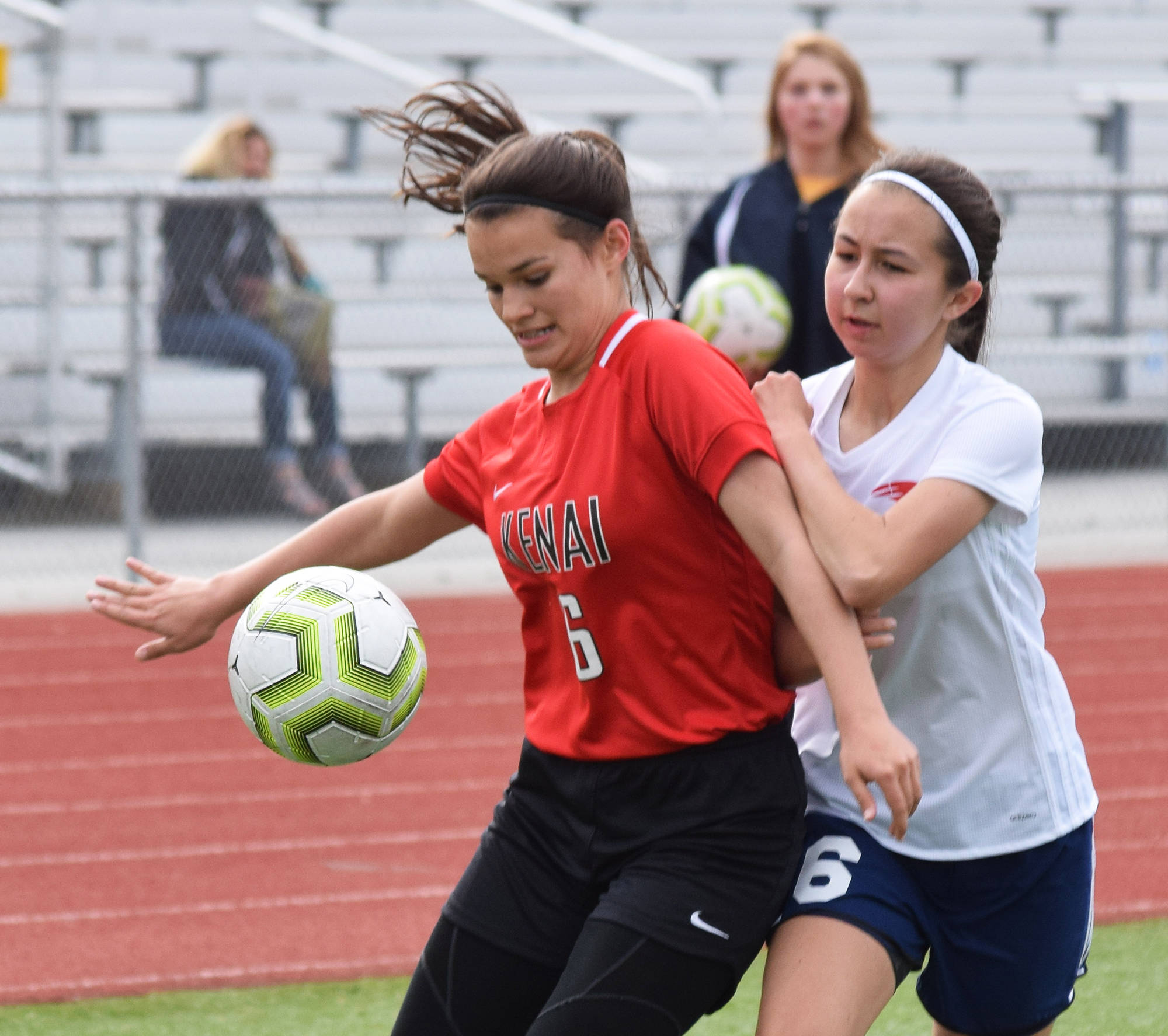 Kenai’s Taylor Pierce (left) battles for the ball with North Pole’s Lauren Schammel Thursday, May 23, 2019, at the Div. II state soccer championships in Eagle River. (Photo by Joey Klecka/Peninsula Clarion)
