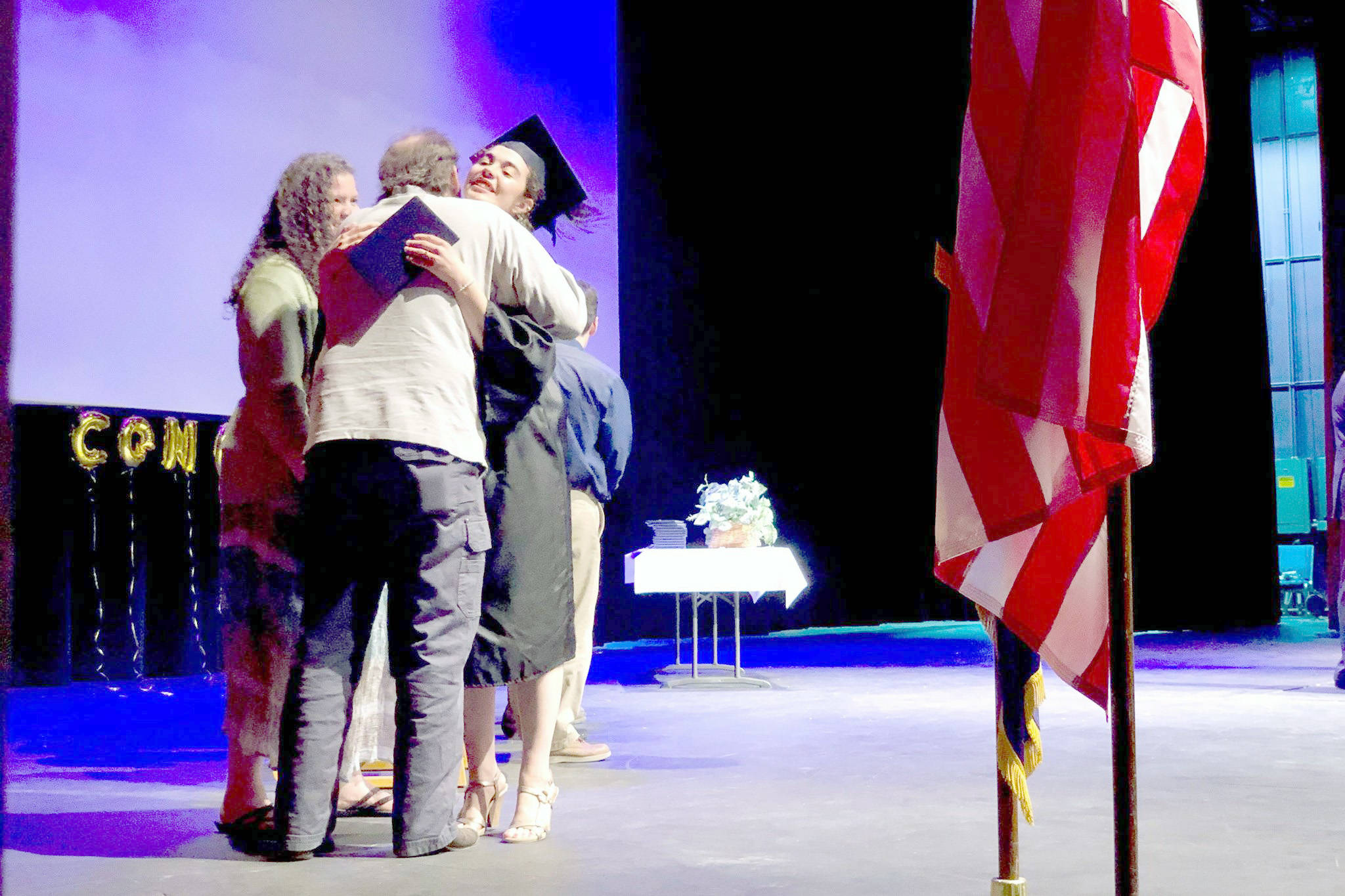 Graduate Emerald Miller receives her high school diploma from her parents at the Kenai Peninsula Borough School District Connections home-school program graduation ceremony at Soldotna High School on Thursday. (Photo by Victoria Petersen/Peninsula Clarion)