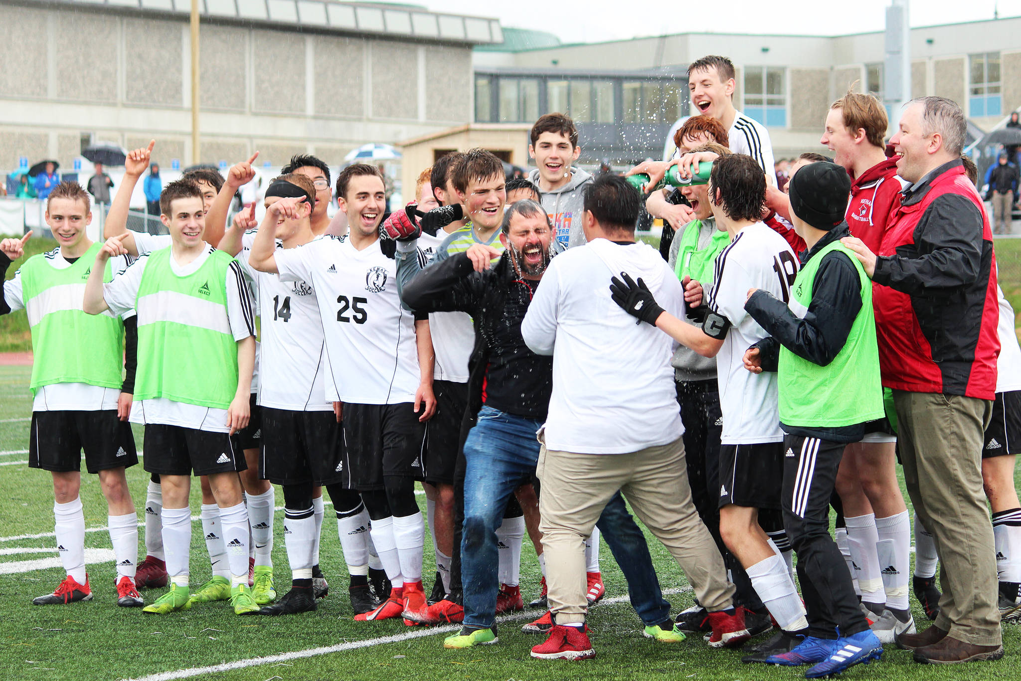 Members of the Kenai boys soccer team dump water on their head coach, Shane Lopez, in celebration of their win over Juneau on Saturday, to claim the Division II state soccer championship title. The game was played at Service High School in Anchorage. (Photo by Megan Pacer/Homer News)