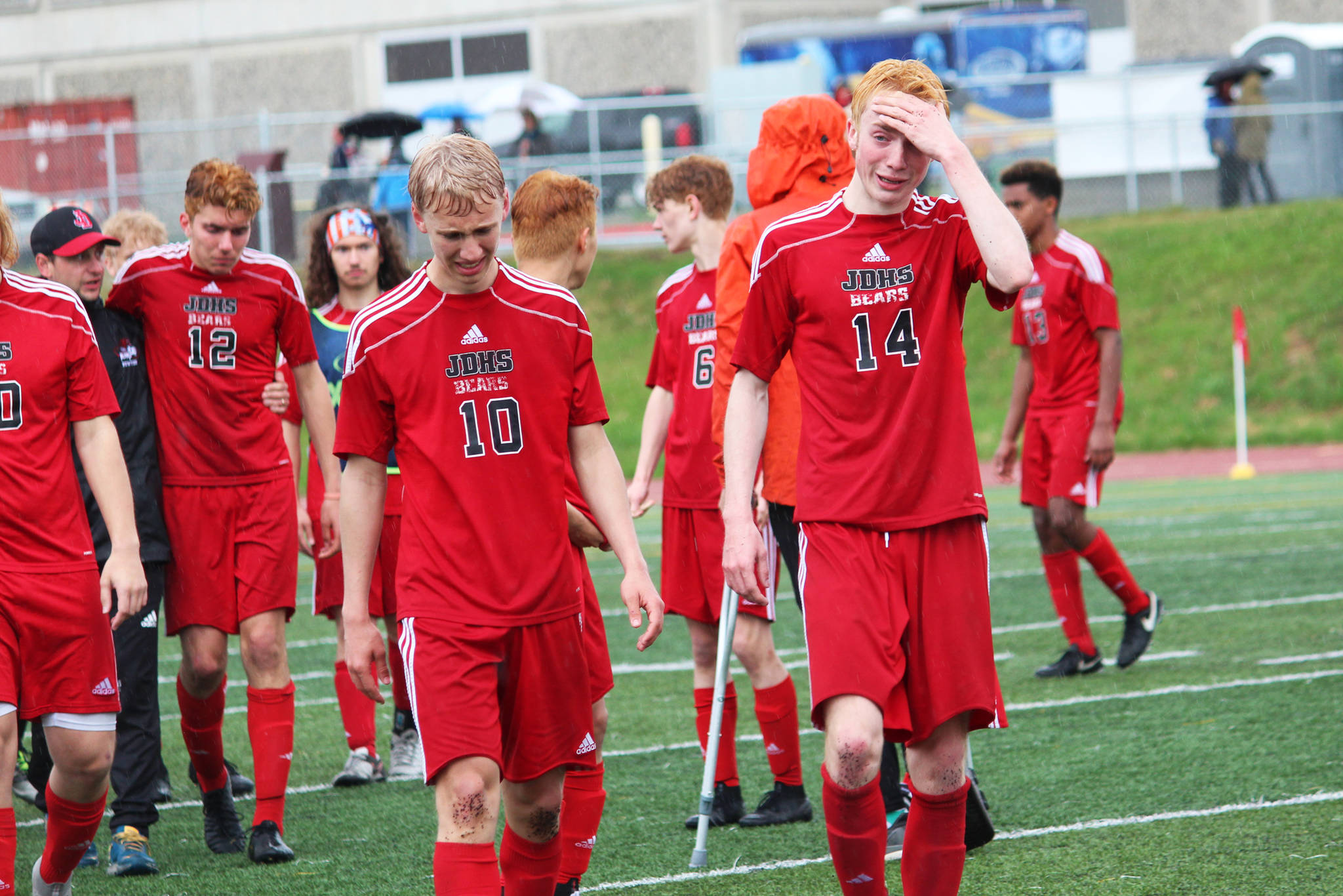 Members of the Juneau Douglas boys soccer team walk off the field in tears after a 3-2 loss to Kenai in the championship game of the Division II state soccer tournament Saturday. May 25, 2019 at Service High School in Anchorage, Alaska. The game went into three halves of overtime before it was over. (Photo by Megan Pacer/Homer News)