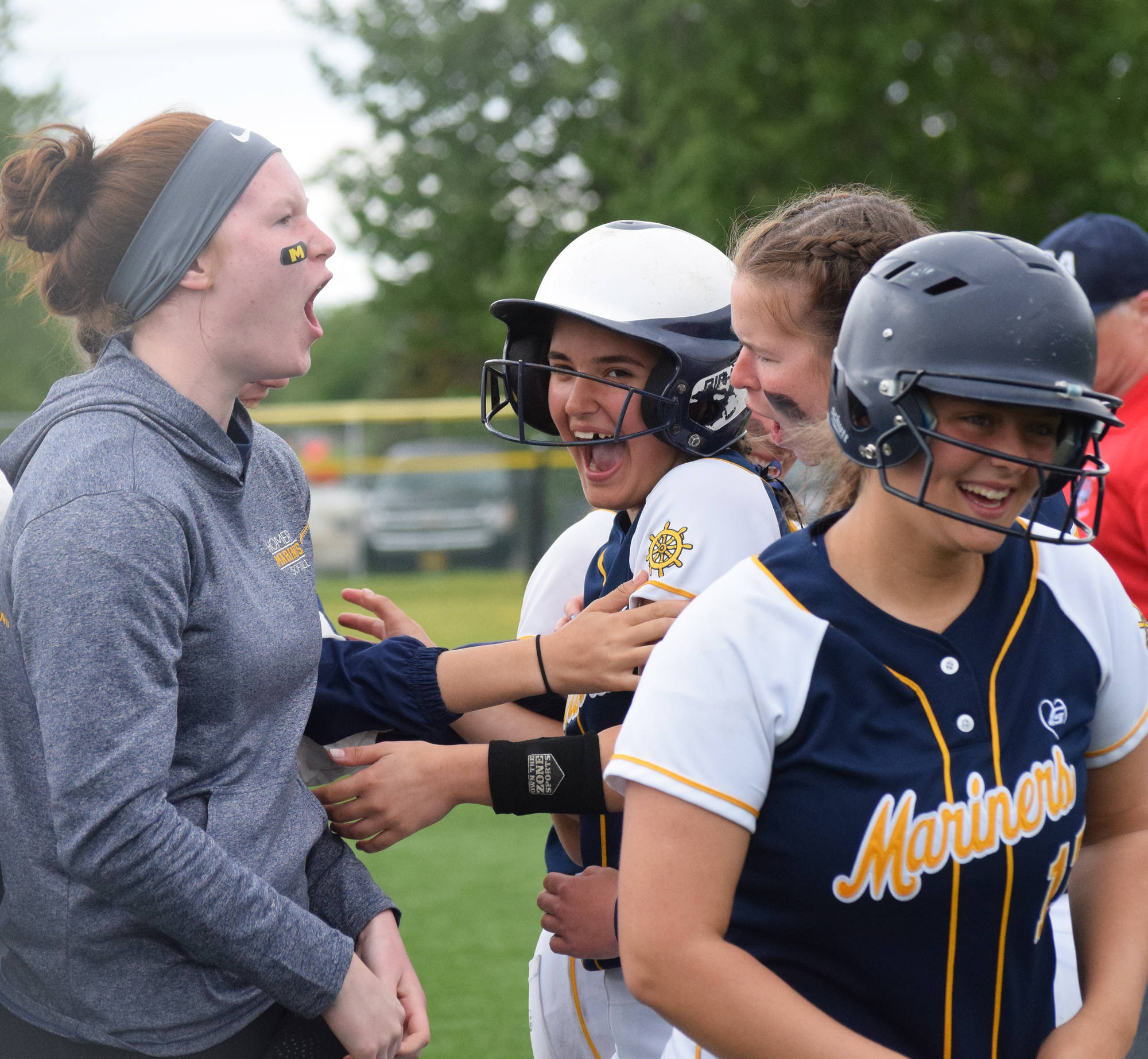 Homer’s Annalynn Brown (center) is mobbed by teammates after hitting a home run against Delta Junction at the Division II state softball tournament Friday, May 31, 2019, at Cartee Fields in Anchorage, Alaska.