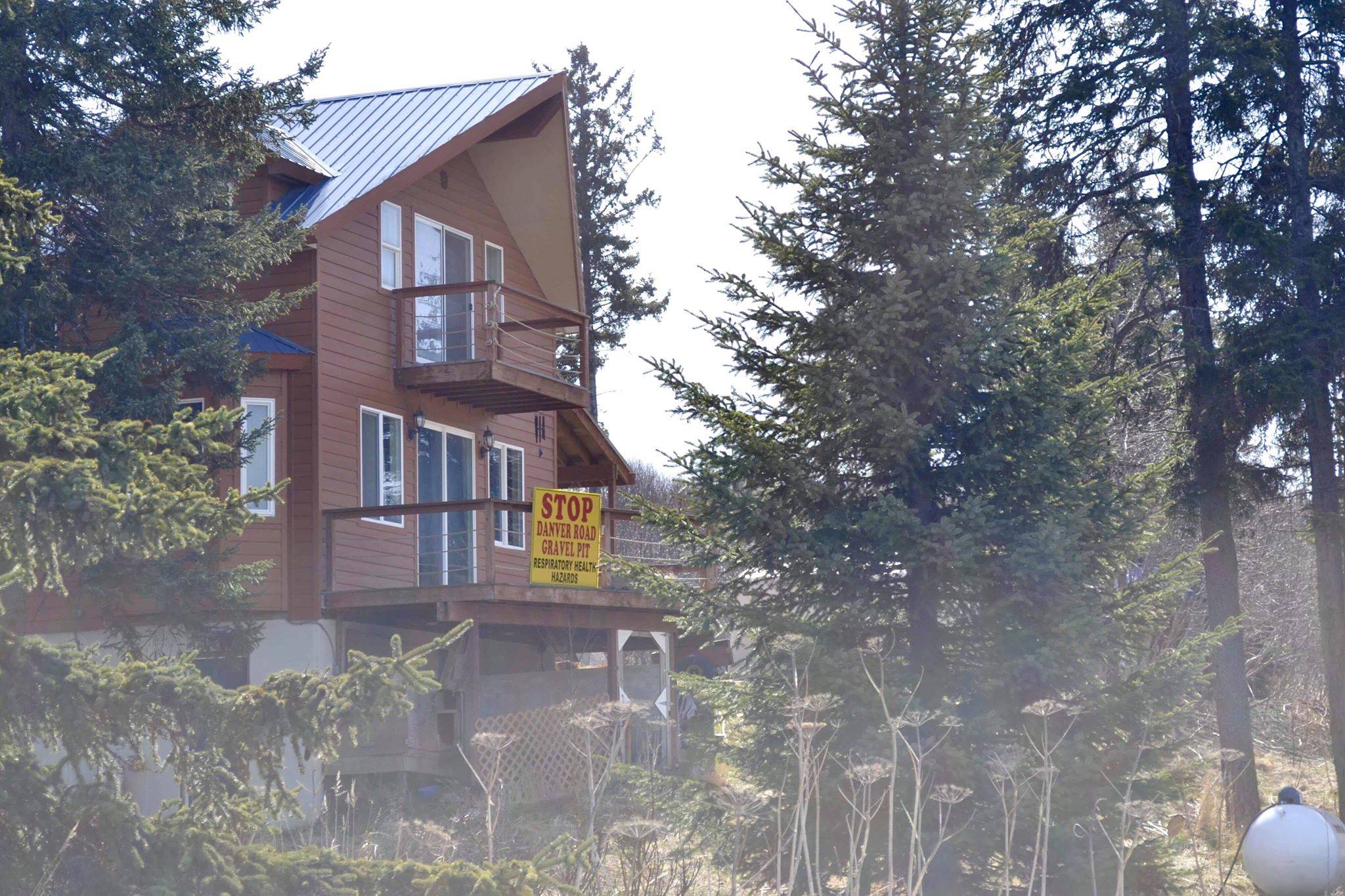 Several homes and businesses in the neighborhood near the proposed Beachcomber LLC gravel pit posted signs opposing excavation in the area, on May 2, 2019, in Anchor Point, Alaska. (Photo by Victoria Petersen/Peninsula Clarion)