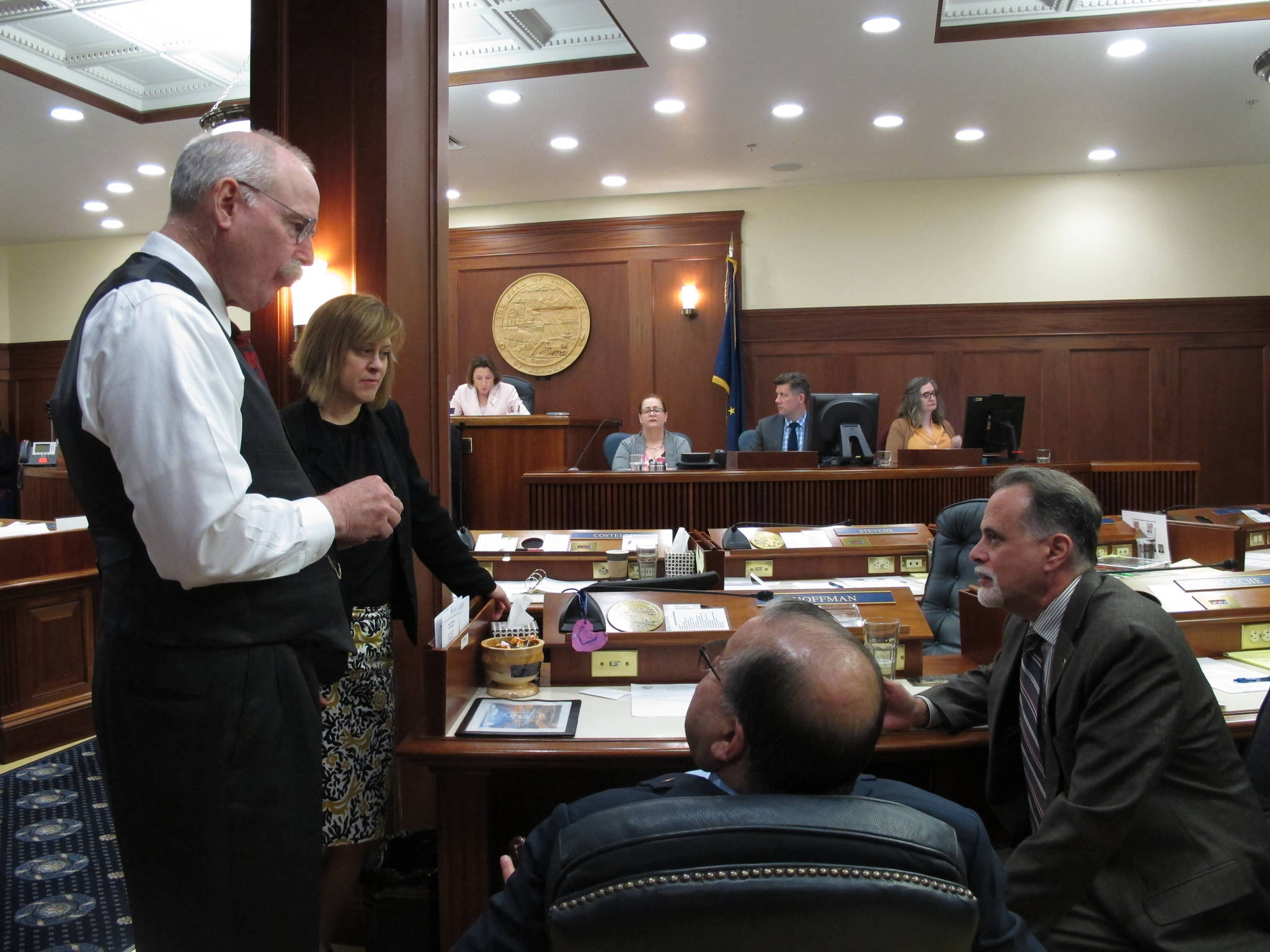 From left, Alaska Sens. Bert Stedman, Mia Costello, Lyman Hoffman and Peter Micciche speak during a break on the Senate floor on Tuesday, June 4, 2019, in Juneau, Alaska. The Senate on Tuesday failed to pass a bill that would have paid a full dividend from Alaska’s oil-wealth fund, the Alaska Permanent Fund, this year. (AP Photo/Becky Bohrer)
