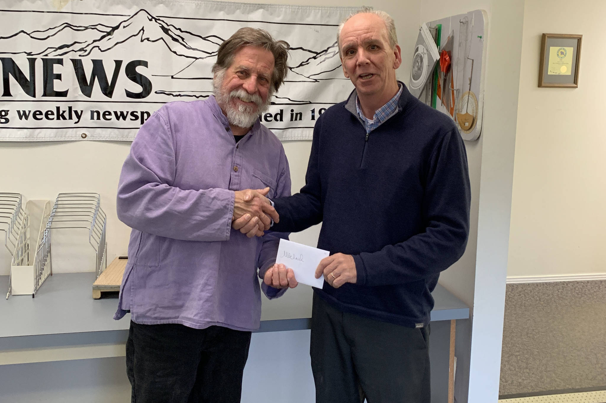 Homer News Editor Michael Armstrong, left, is presented with an award from Publisher Jeff Hayden. (Photo provided by the Homer News)