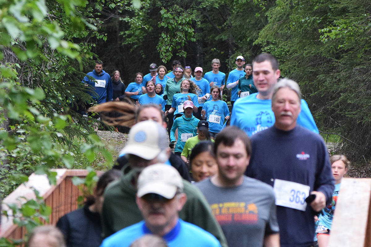 The field of 5K runners stream through the woods Saturday, June 8, 2019, at the Run for the River 5-kilometer/10-mile races in Soldotna, Alaska. (Photo by Joey Klecka/Peninsula Clarion)