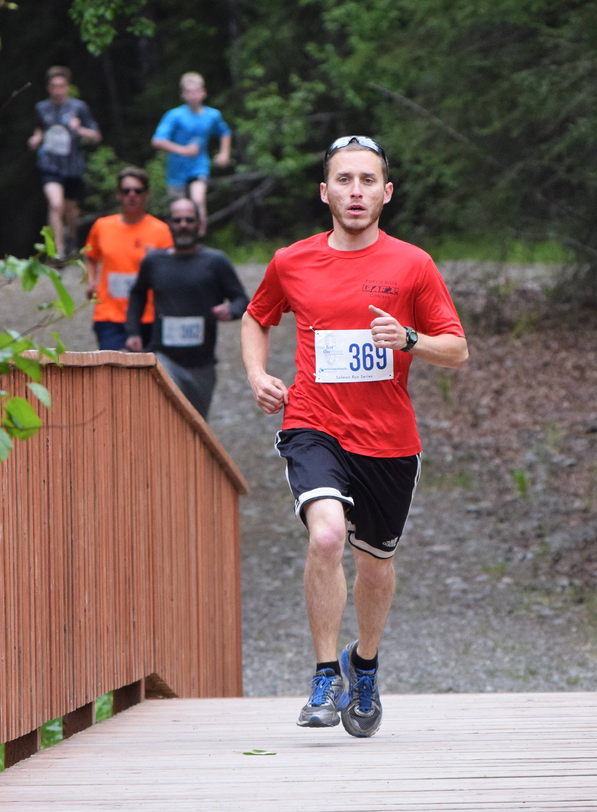 Eventual men’s 5K winner Spencer Townsend leads the field early over a bridge Saturday, June 8, 2019, at the Run for the River 5-kilometer/10-mile races in Soldotna, Alaska. (Photo by Joey Klecka/Peninsula Clarion)