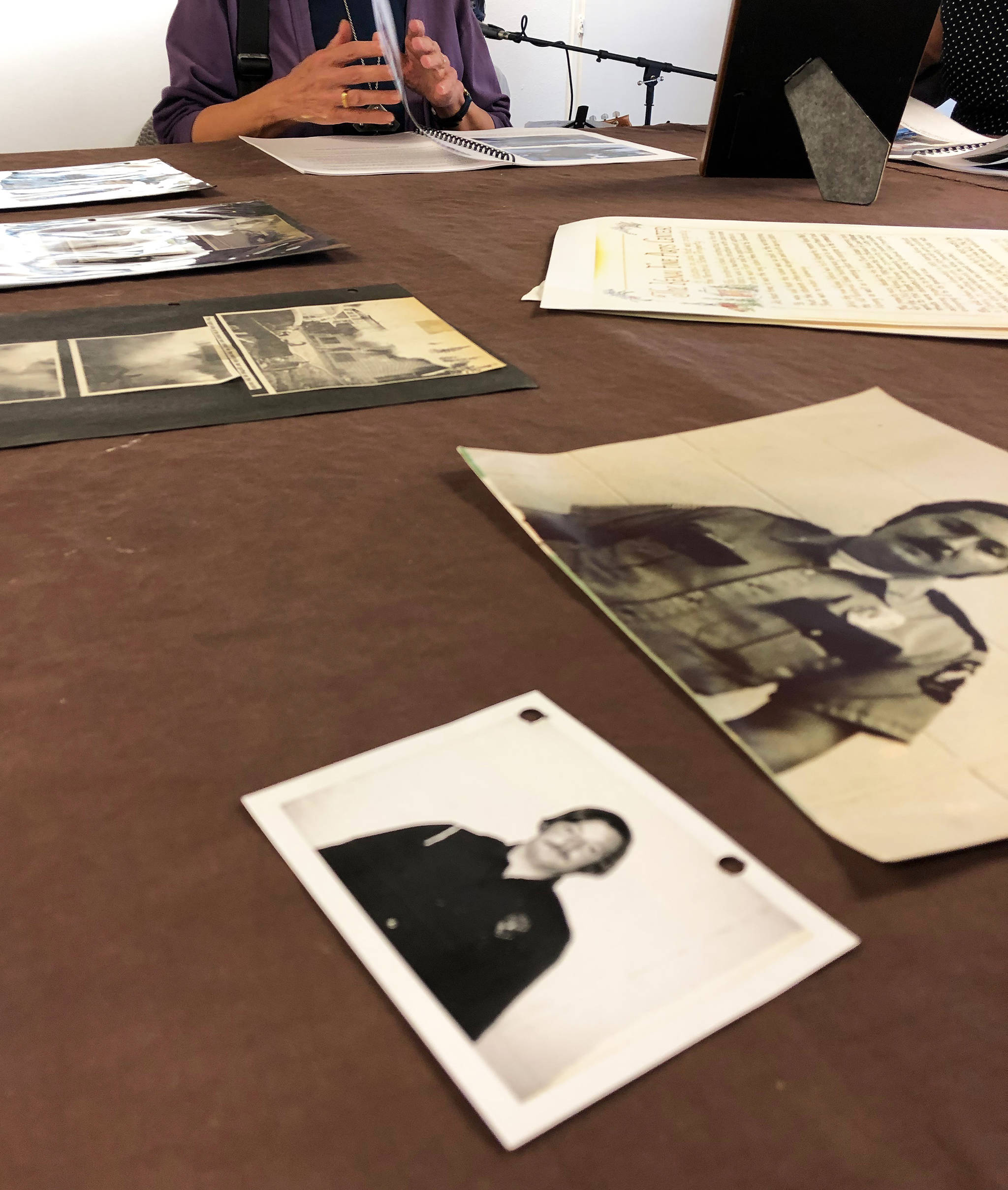 Old photographs of members of the Kenai Volunteer Fire Department lay on a table Thursday, June 6, 2019, during the opening reception to the June exhibit Historic Buildings of Kenai. (Photo by Joey Klecka/Peninsula Clarion)