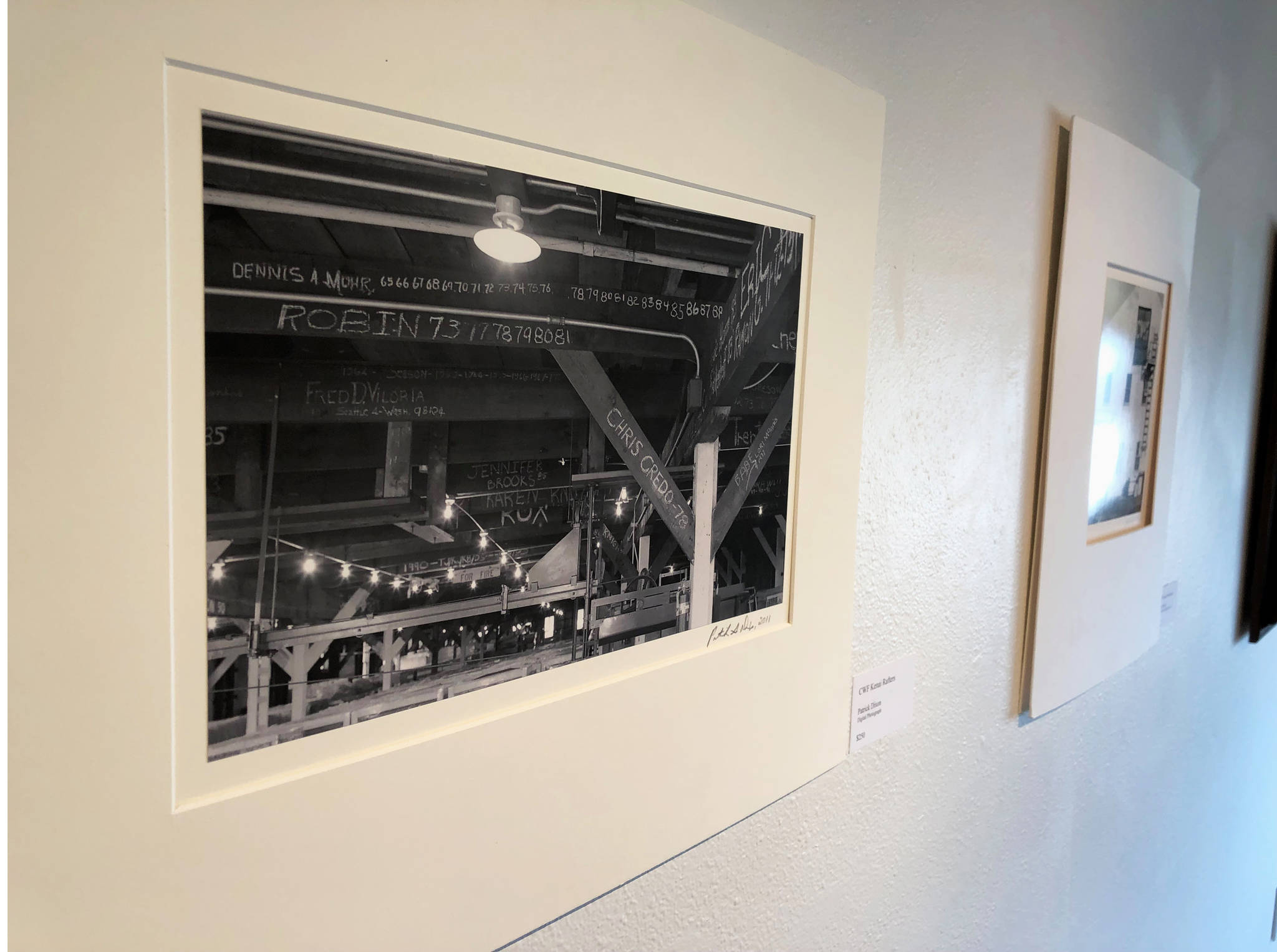 A photograph entitled “CWF Rafters” by Patrick Dixon hangs on the wall of the Kenai Fine Art Center Thursday, June 6, 2019, during the opening reception to the June exhibit Historic Buildings of Kenai. (Photo by Joey Klecka/Peninsula Clarion)