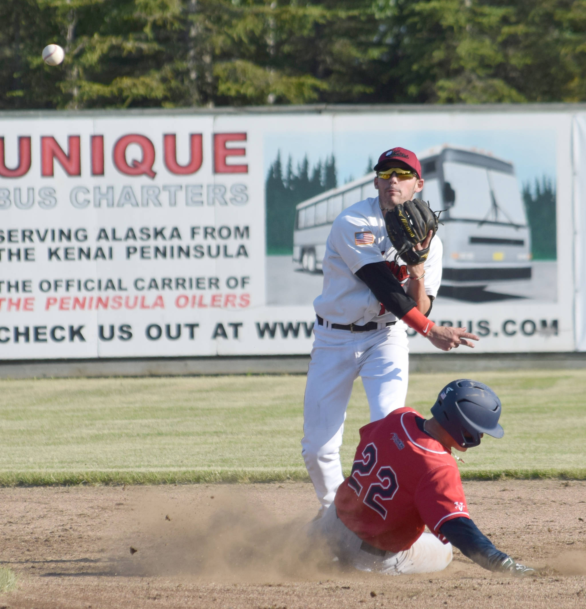 Peninsula Oilers second baseman Victor Carlino turns a double play in front of sliding Jess Davis of the Chugiak-Eagle River Chinooks on Wednesday, June 12, 2019, at Coral Seymour Memorial Park in Kenai, Alaska. (Photo by Jeff Helminiak/Peninsula Clarion)