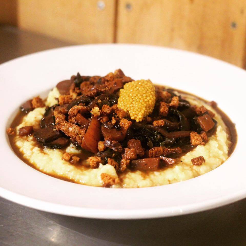 Red wine-braised veggies and smoked carrots over grits with pickled mustard seeds are pictured. The dish is just one of the many vegan and gluten-free items diners might find at Kingfisher Roadhouse, in Cooper Landing, Alaska. (Photo courtesy of Katherine O’Leary-Cole)