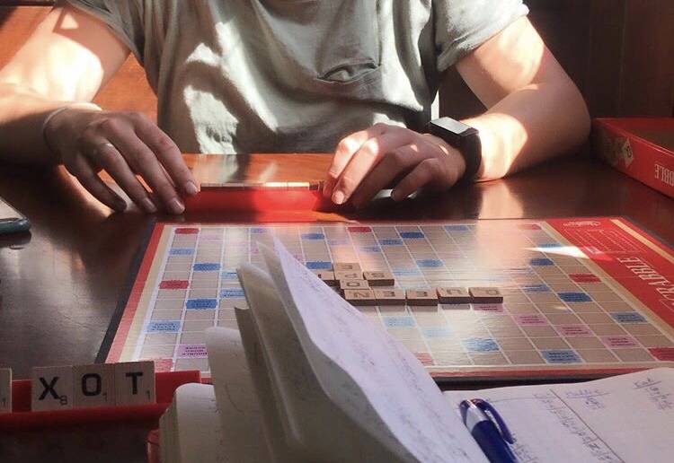 Hallie Bergwall makes a move in a Scrabble game on Thursday at Resurrect Art Coffee House in Seward, Alaska. Bergwall took home the win. (Photo by Kat Sorensen/Peninsula Clarion)