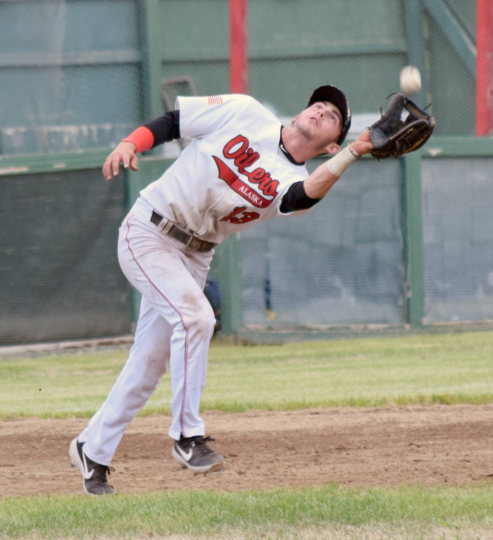 Oilers third baseman Victor Carlino catches a pop-up against the Chugiak-Eagle River Chinooks on Friday at Coral Seymour Memorial Park in Kena. (Photo by Jeff Helminiak/Peninsula Clarion)