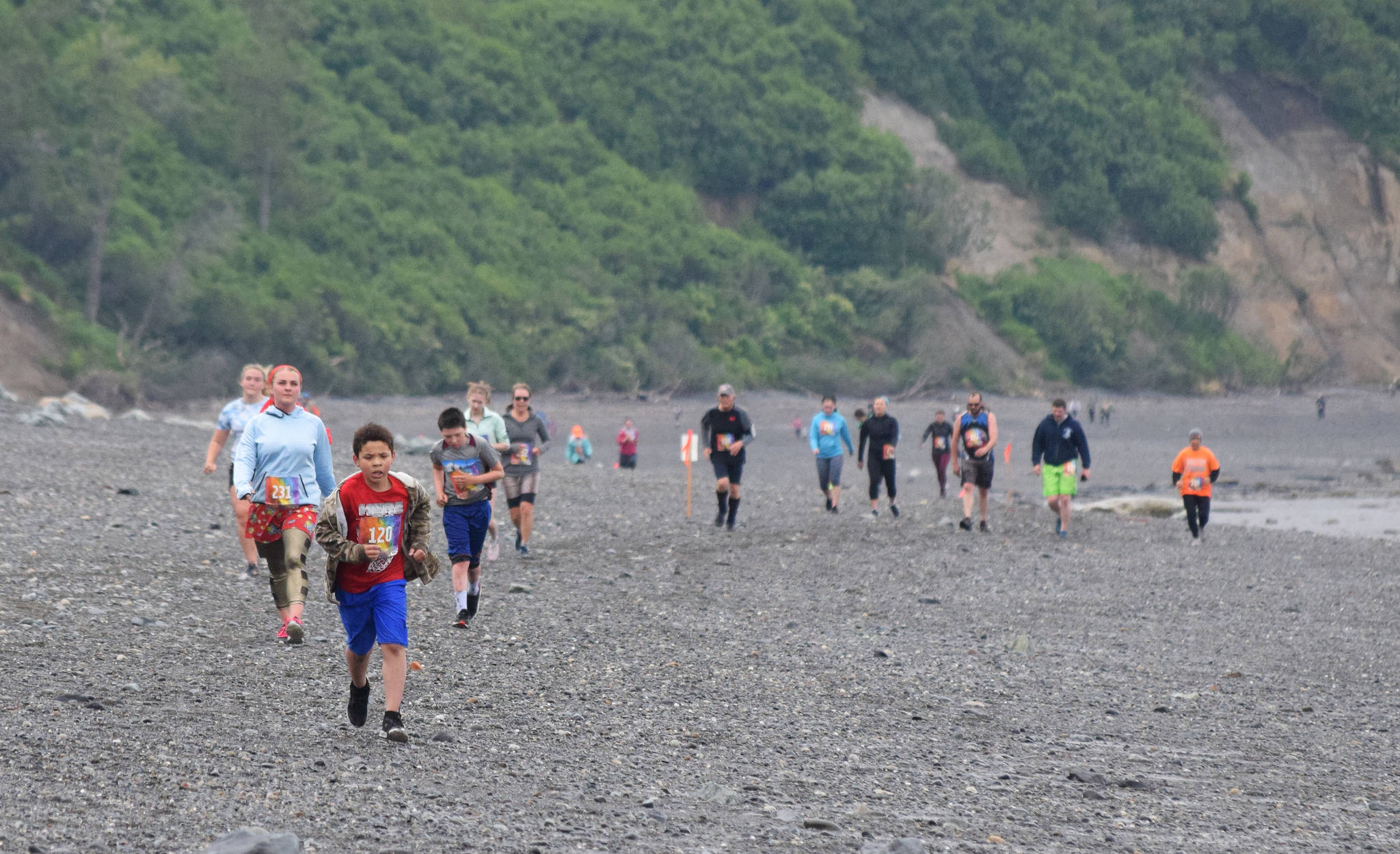 The field of 131 runners race down the beach Saturday, June 15, 2019, at the Ninilchik Clam Scramble Mud and Obstacle Run in Ninilchik, Alaska. (Photo by Joey Klecka/Peninsula Clarion)