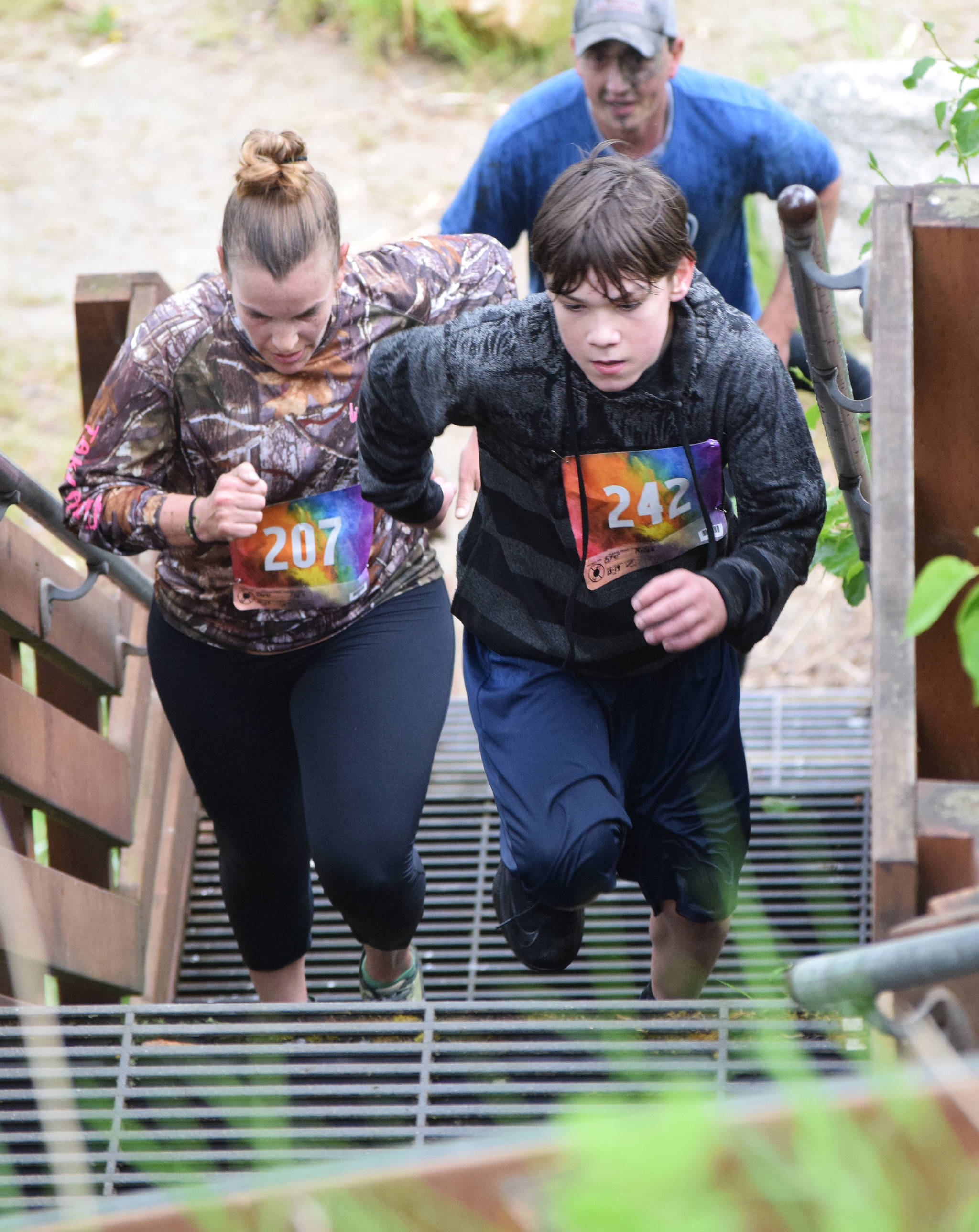 Rylee Fifer (right) leads Julie Mages up the final set of stairs Saturday at the Ninilchik Clam Scramble Mud and Obstacle Run in Ninilchik. (Photo by Joey Klecka/Peninsula Clarion)