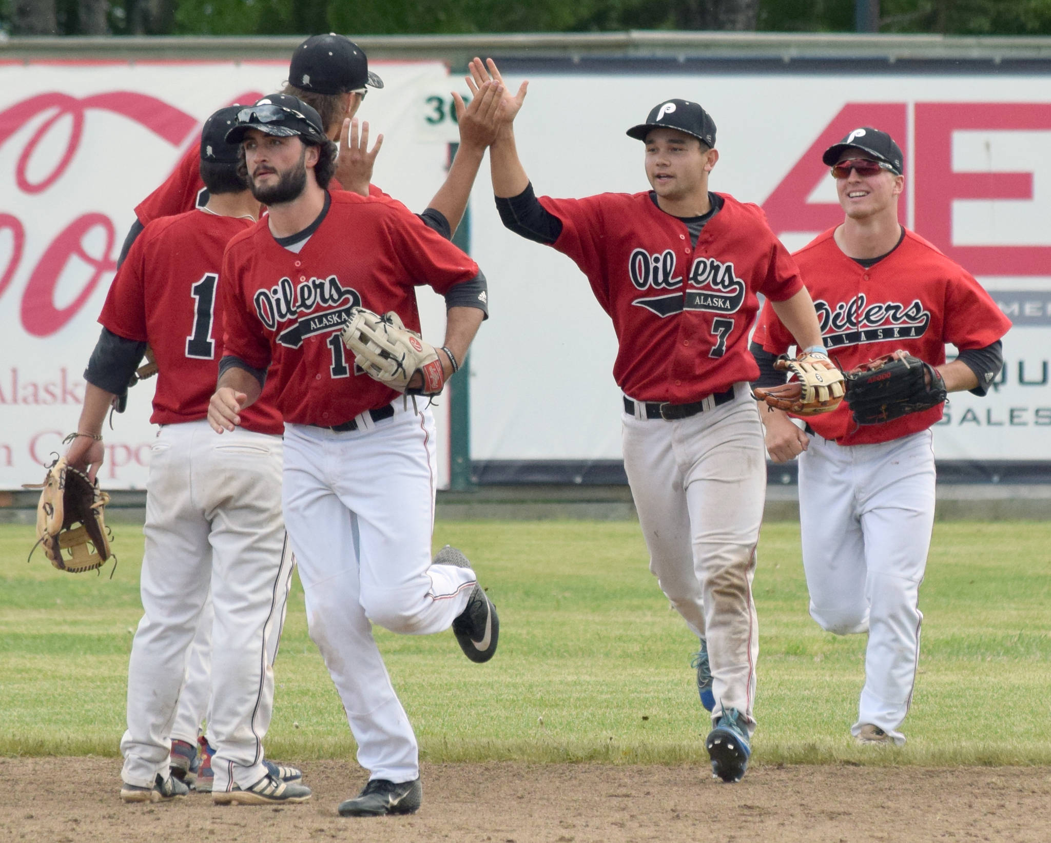 Oilers outfielders Calvin Farris, Camden Vasquez and Paul Steffensen receive congratulations after the Oilers defeated the Chugiak-Eagle River Chinooks on Sunday, June 16, 2019, at Coral Seymour Memorial Park in Kenai, Alaska.