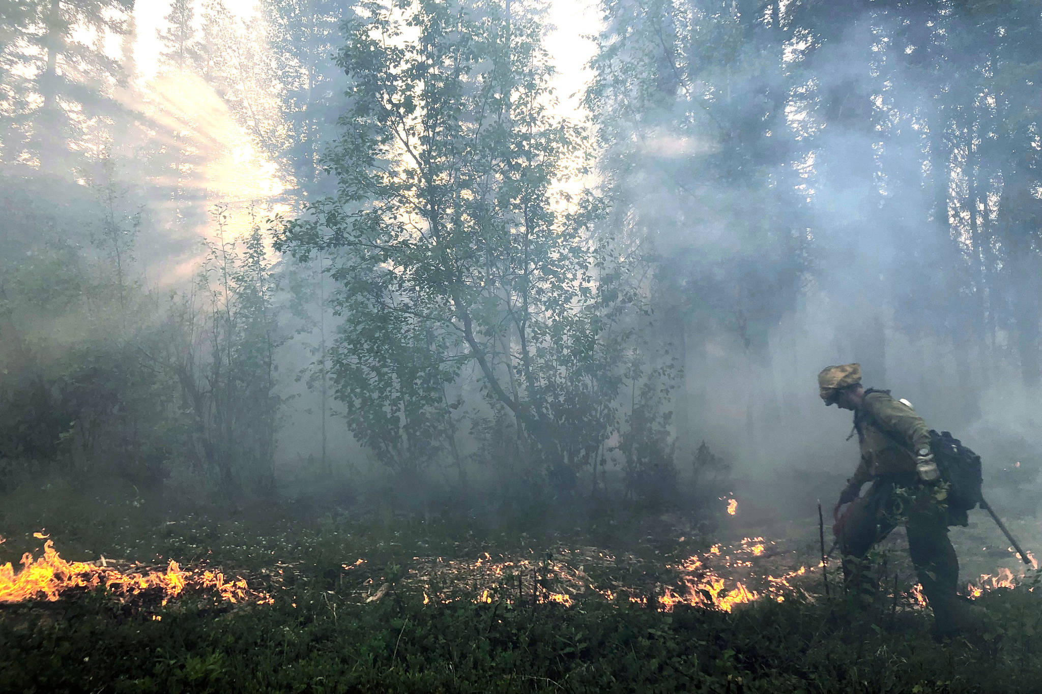 A member of the Gannet Glacier Type 2 Initial Attack Crew uses a drip torch during a burnout operation at the Swan Lake Fire on June 18, 2019. (Photo courtesy Alaska Division of Forestry)