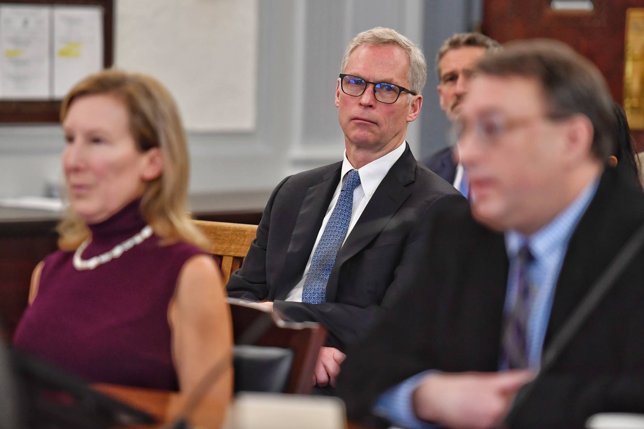 Dr. Jim Johnsen, president of the University of Alaska, center, listens to Donna Arduin, Director of the Office of Management and Budget, left and Mike Barnhill, policy director for the OMB, as their continue to present Gov. Mike Dunleavy’s budget to the Senate Finance Committee at the Capitol on Tuesday, Feb. 18, 2019. (Michael Penn | Juneau Empire File)