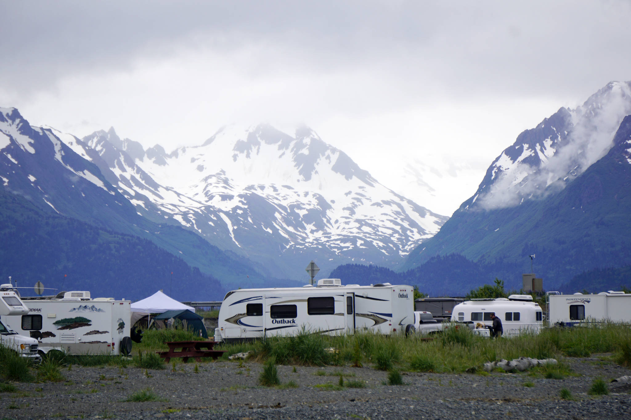 The Kenai Mountains across Kachemak Bay rise behind the Mariner Park Campground on the Homer Spit in Homer, Alaska, as seen on June 15, 2019. The city campground offers both tent and motorhome camping. Although the facilities are minimal, the beachfront view is amazing. (Photo by Michael Armstrong/Homer News)