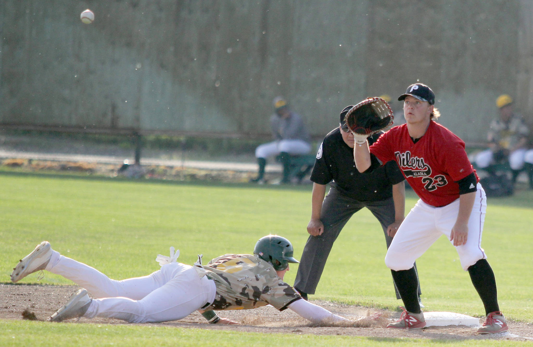 Peninsula Oilers’ Connor McCord takes the throw at first as Mat-Su’s Justin Kirby slides back during an 11-5 loss to the Miners on Friday in Palmer. (Photo by Jeremiah Bartz/Frontiersman)