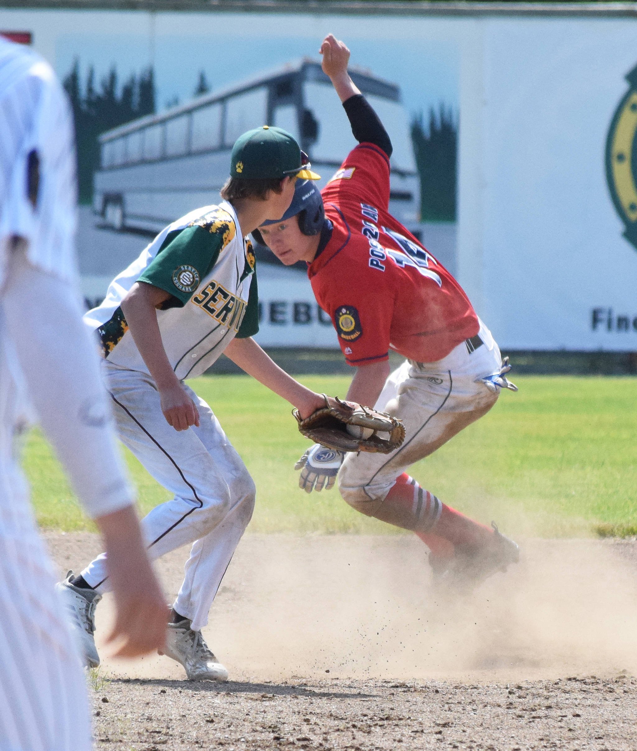 The Twins’ Mose Hayes evades the tag of Service second baseman Kyle Andrew (left) Saturday, June 22, 2019, at Coral Seymour Memorial Park in Kenai. (Photo by Joey Klecka/Peninsula Clarion)