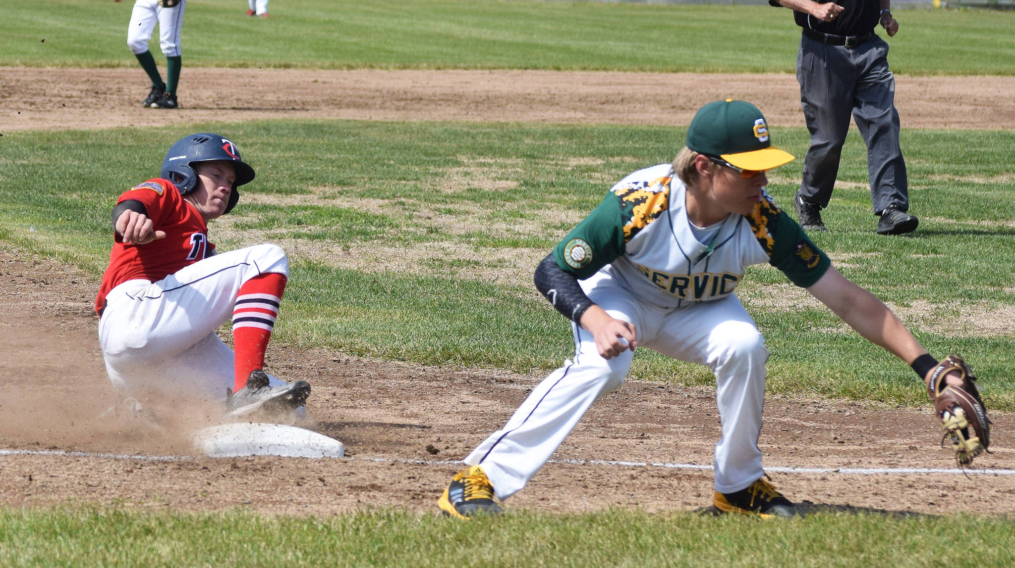 The Twins’ Mose Hayes slides into third base Saturday, June 22, 2019, ahead of the tag of Service’s Dawson Beaty at Coral Seymour Memorial Park in Kenai. (Photo by Joey Klecka/Peninsula Clarion)