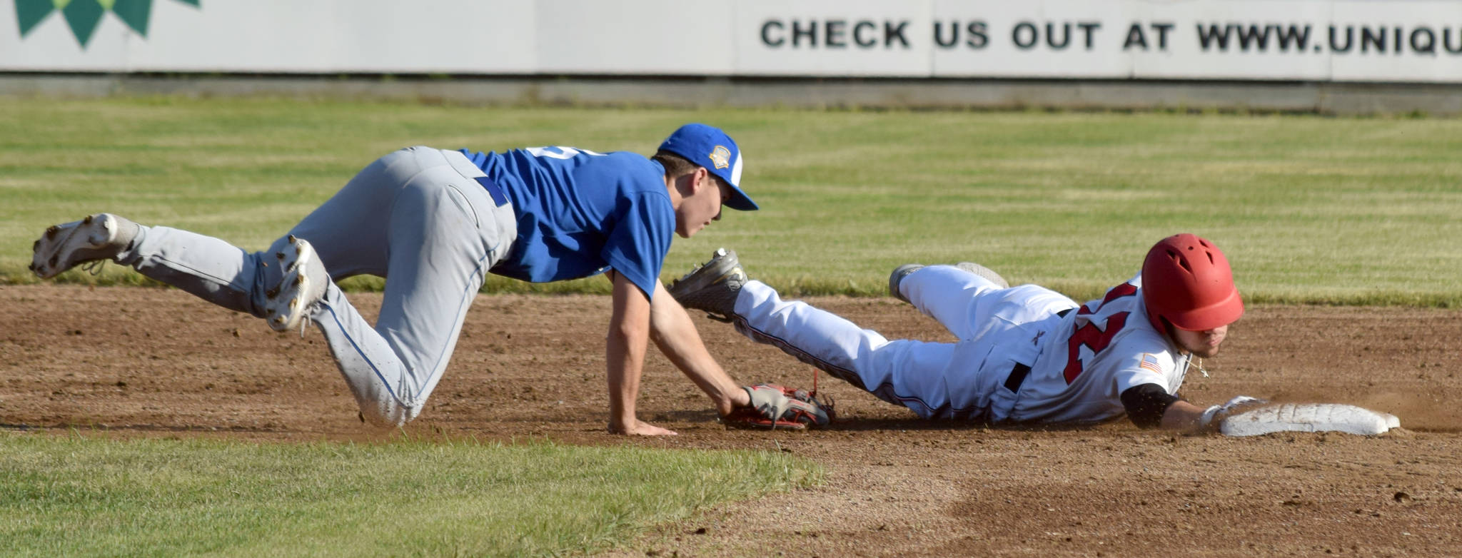 Bobby Goodloe of the Peninsula Oilers slides past Matt Ottino of the Anchorage Glacier Pilots on Thursday, June 27, 2019, at Coral Seymour Memorial Park in Kenai, Alaska. (Photo by Jeff Helminiak/Peninsula Clarion)