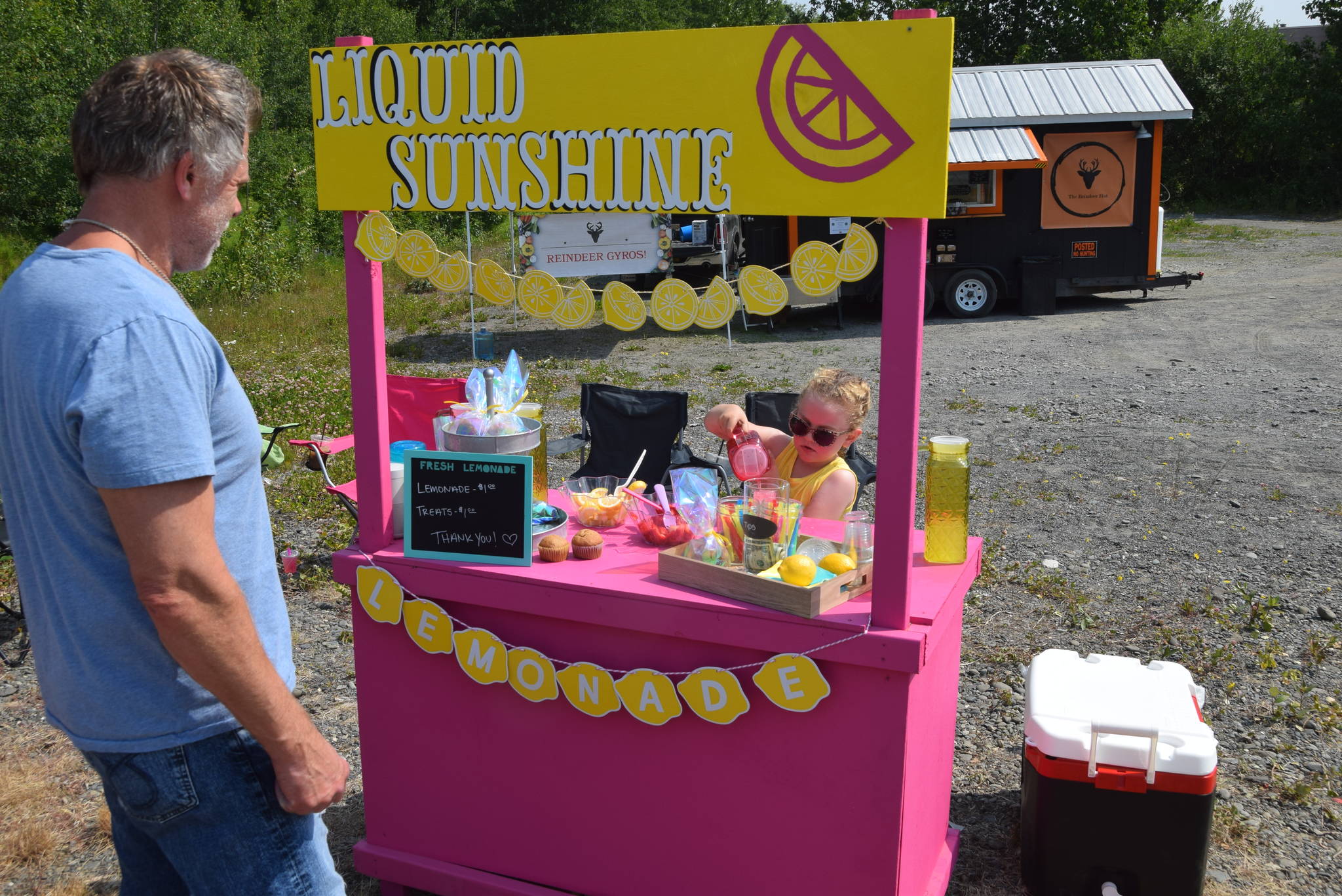 Ava McCaughey serves a customer at her lemonade stand on Binkley Street during Lemonade Day in Soldotna, Alaska on June 29, 2019. (Photo by Brian Mazurek/Peninsula Clarion)