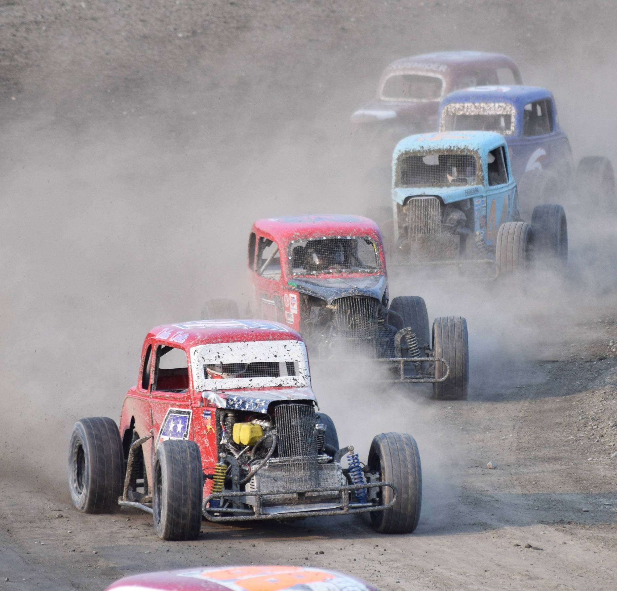 Dallas Dalton in the #4 Legends car leads a group of racers around a turn Saturday, June 29, 2019, at Twin Cities Raceway in Kenai, Alaska. (Photo by Joey Klecka/Peninsula Clarion)