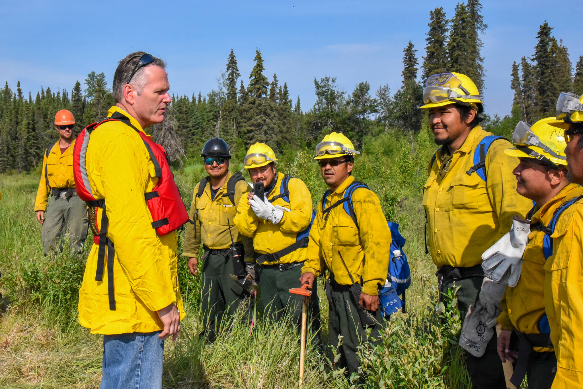 Gov. Mike Dunleavy, left, speaks with the Kobuk Valley Type 2 Hand Crew along the East Fork Moose River on Monday. (Courtesy photo)