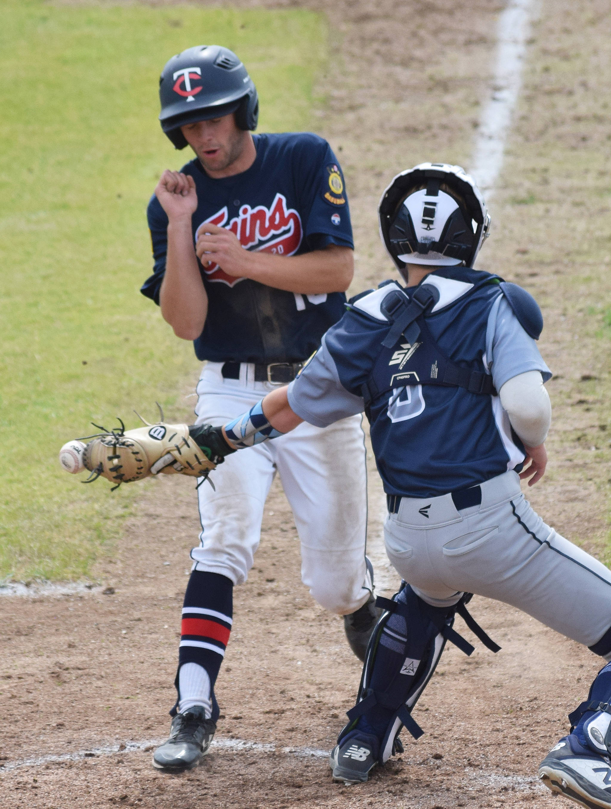 Eagle River catcher Cameron Witte (right) attempts to tag out Twins baserunner Seth Adkins at home plate Tuesday at the Bill Miller Big Fish Wood Bat Tournament at Coral Seymour Memorial Park in Kenai. (Photo by Joey Klecka/Peninsula Clarion)