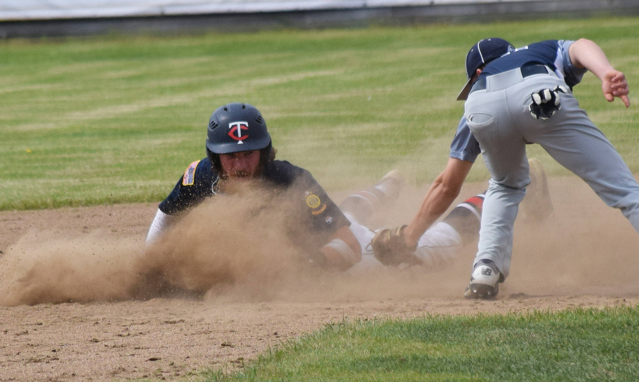 The Twins’ David Michael safely slides into second base ahead of the tag of Eagle River’s Devin Wilcox (right) Tuesday at the Bill Miller Big Fish Wood Bat Tournament at Coral Seymour Memorial Park in Kenai. (Photo by Joey Klecka/Peninsula Clarion