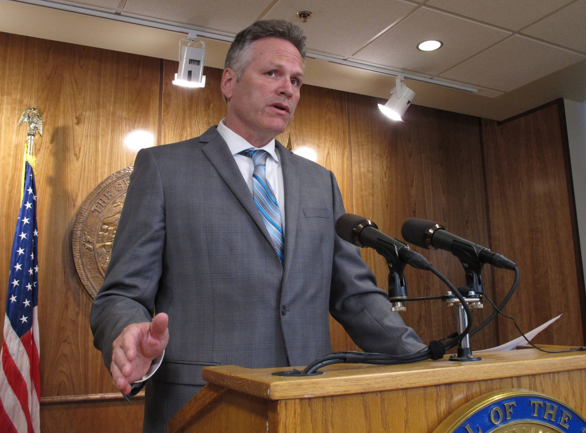 Gov. Mike Dunleavy speaks to reporters about his budget vetoes at the state Capitol in Juneau on Friday. (AP Photo/Becky Bohrer)