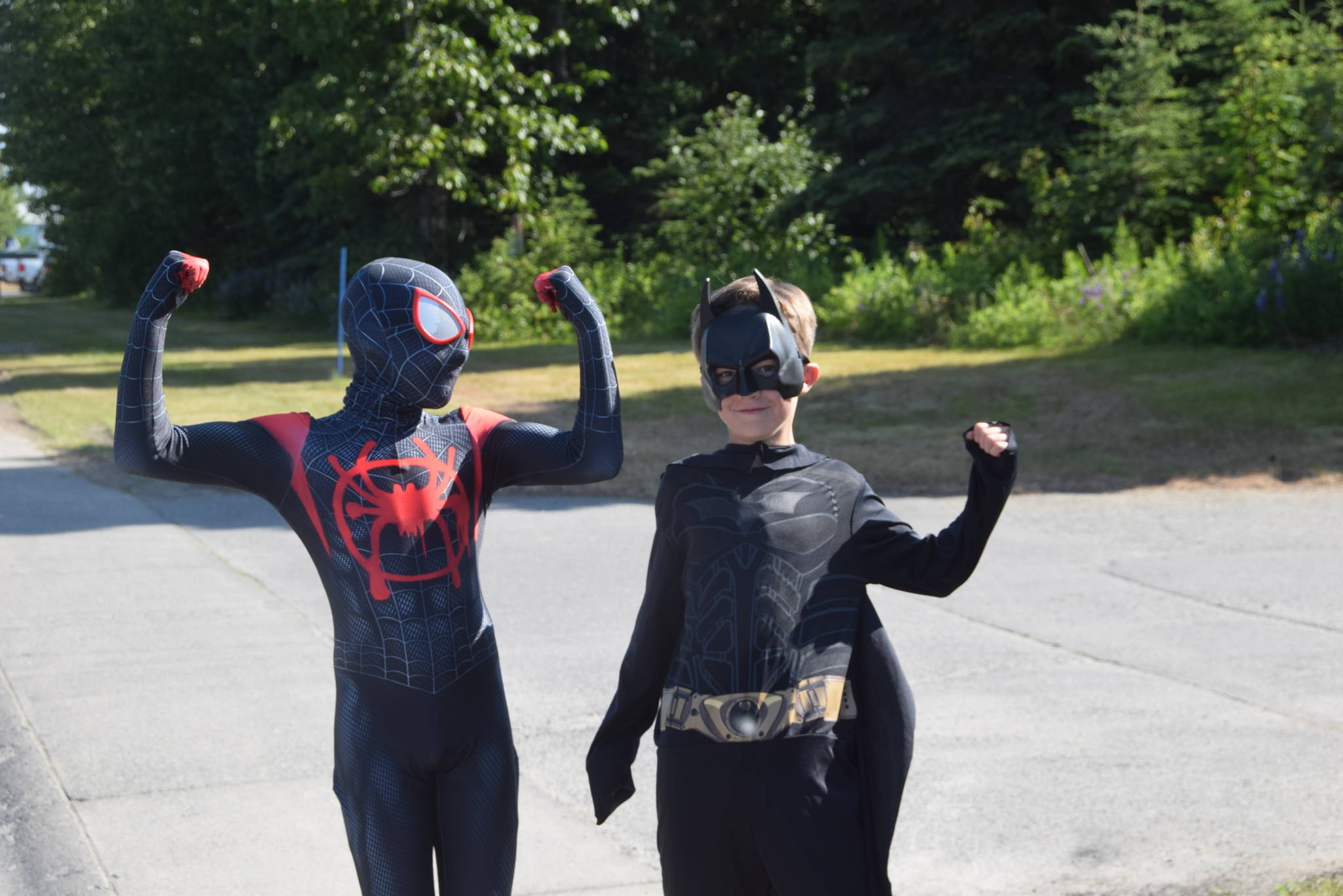 Spiderman and Batman flex their muscles during the July 4th parade in Kenai, Alaska. (Photo by Brian Mazurek/Peninsula Clarion)