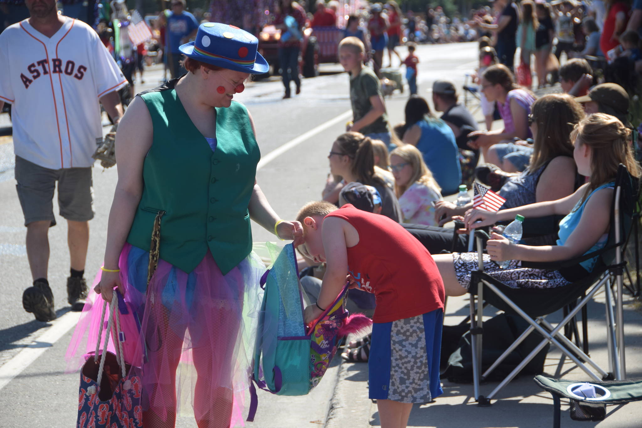 Buttons the clown hands out candy to kids during the July 4th parade in Kenai, Alaska. (Photo by Brian Mazurek/Peninsula Clarion)