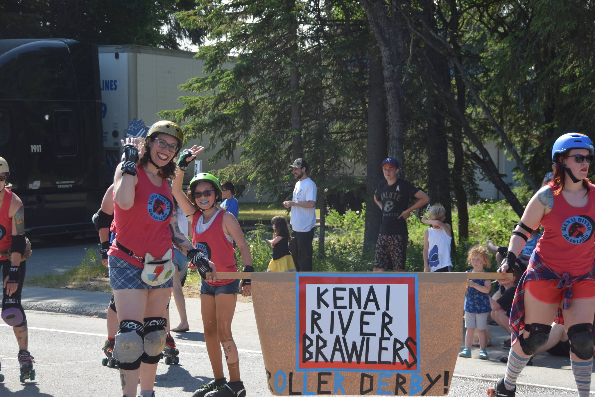 Members of the Kenai River Brawlers roller derby team wave to the crowd during the July 4th parade in Kenai, Alaska. (Photo by Brian Mazurek/Peninsula Clarion)