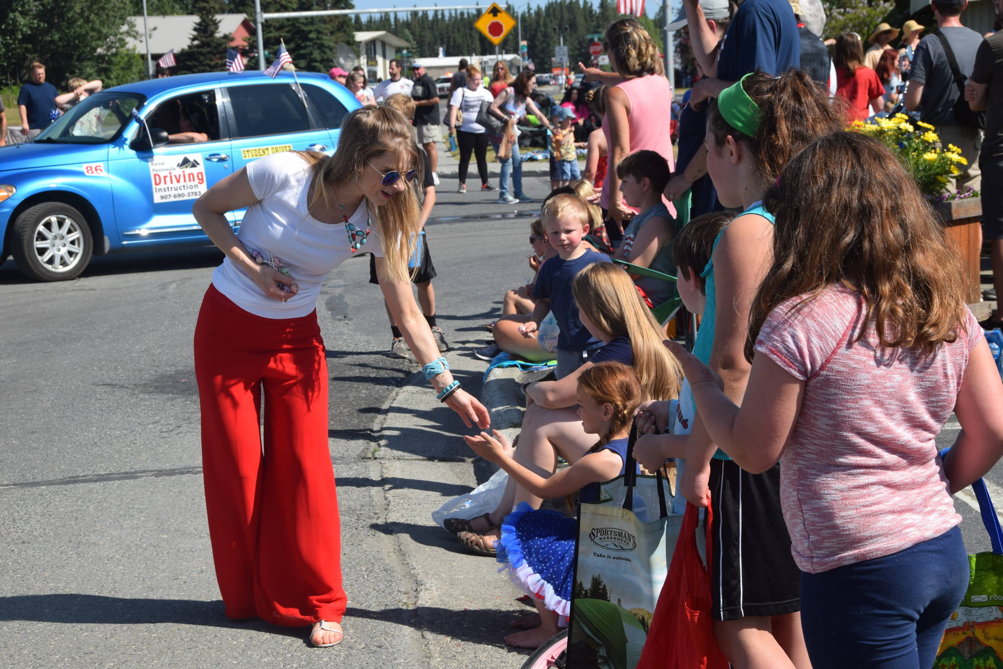 A volunteer from AK Kids hands out candy during the July 4th parade in Kenai, Alaska. (Photo by Brian Mazurek/Peninsula Clarion)
