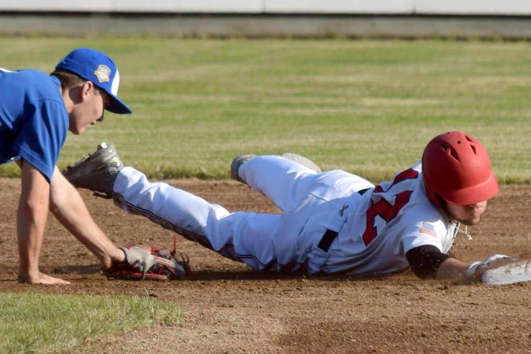 Bobby Goodloe of the Peninsula Oilers slides past Matt Ottino of the Anchorage Glacier Pilots on Thursday, June 27, 2019, at Coral Seymour Memorial Park in Kenai, Alaska. (Photo by Jeff Helminiak/Peninsula Clarion)