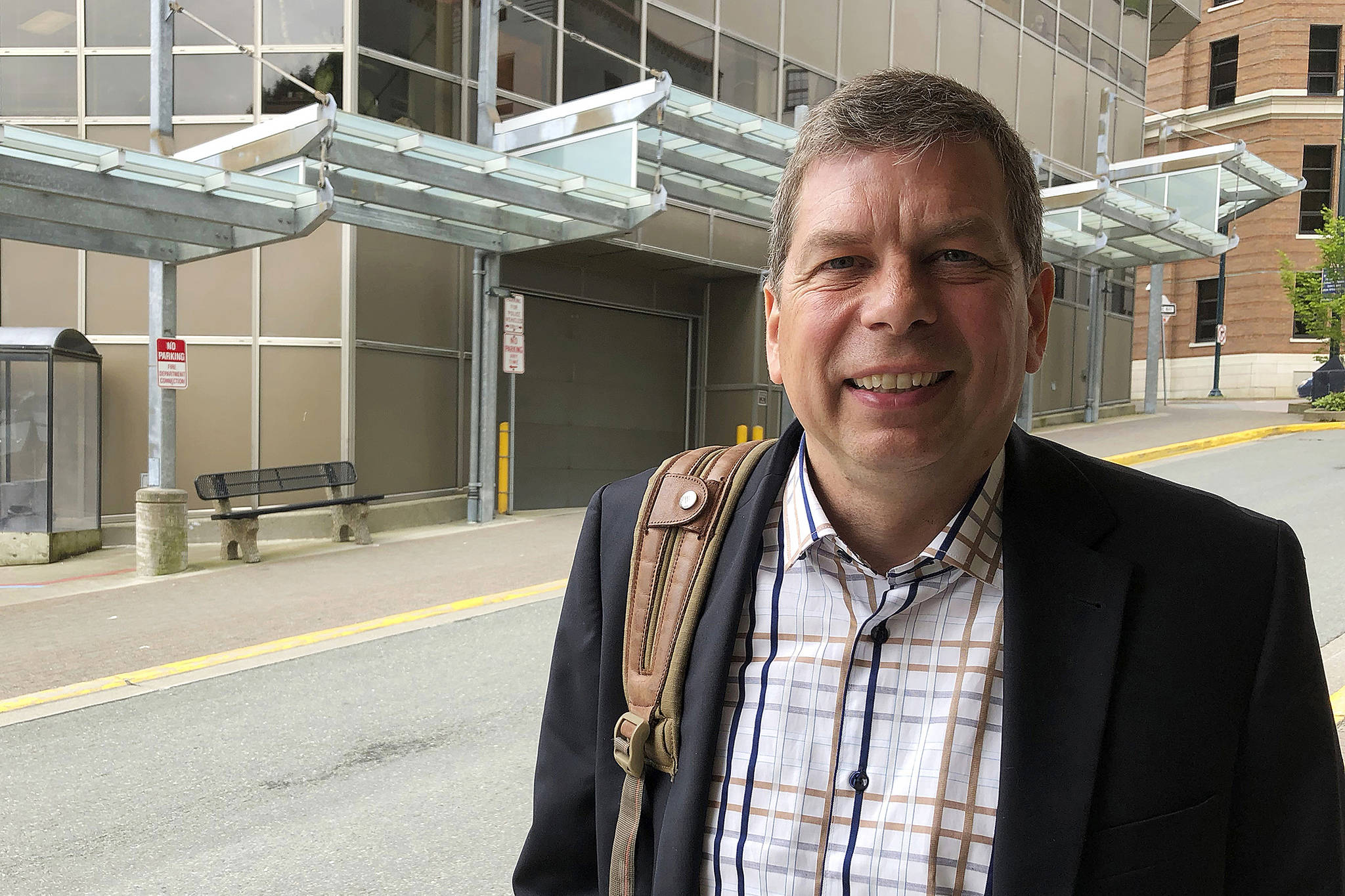 In this June 28, 2018, photo, Democrat Mark Begich poses outside a downtown office building in Juneau. (AP Photo/Becky Bohrer)
