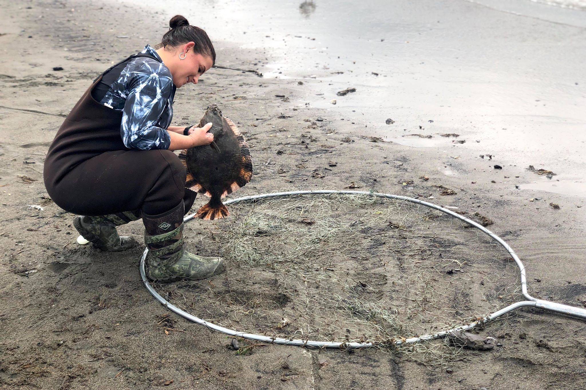 Katherine Green catches a flounder while dipnetting in the Kenai River on Wednesday, July 10, 2019, in Kenai, Alaska. (Photo by Victoria Petersen/Peninsula Clarion)                                People from all over Alaska come to fish on opening day of the Kenai River personal use dipnetting fishery, Wednesday, July 10, 2019, in Kenai, Alaska. (Photo by Victoria Petersen/Peninsula Clarion)