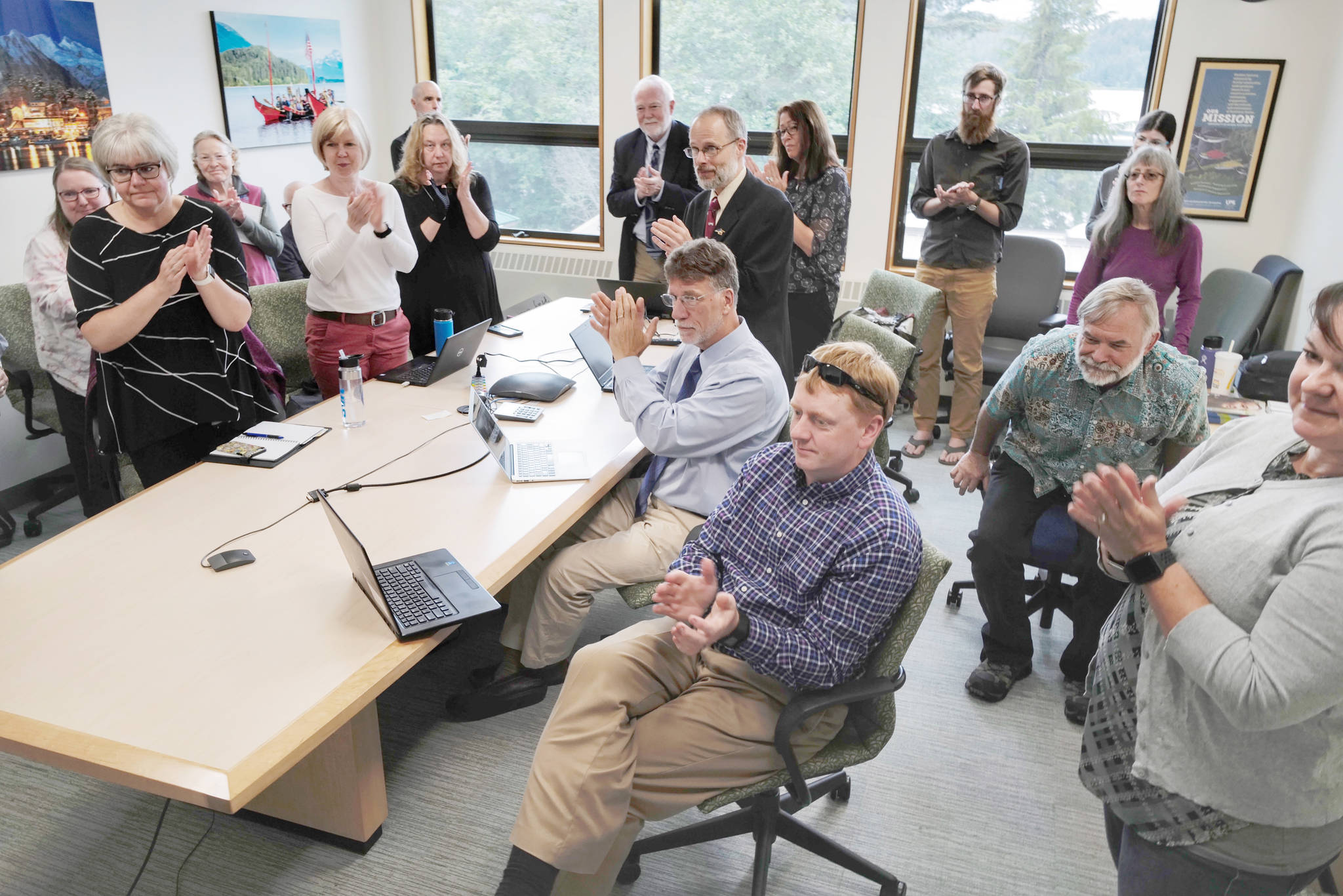 Michael Penn | Juneau Empire                                University of Alaska Southeast administrators and staff applaud a speech by Sen. Click Bishop, R-Fairbanks, as they watch an online meeting being held Monday at UA campuses around the state on Gov. Mike Dunleavy’s budget cuts.