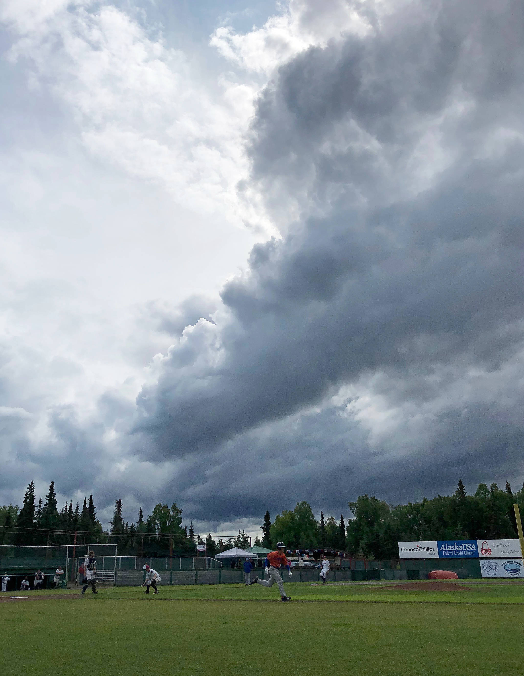 The Legion Twins and Palmer Moose resume play after a passing shower soaked the field Tuesday, July 16, 2019, at Coral Seymour Memorial Park in Kenai, Alaska. (Photo by Joey Klecka/Peninsula Clarion)