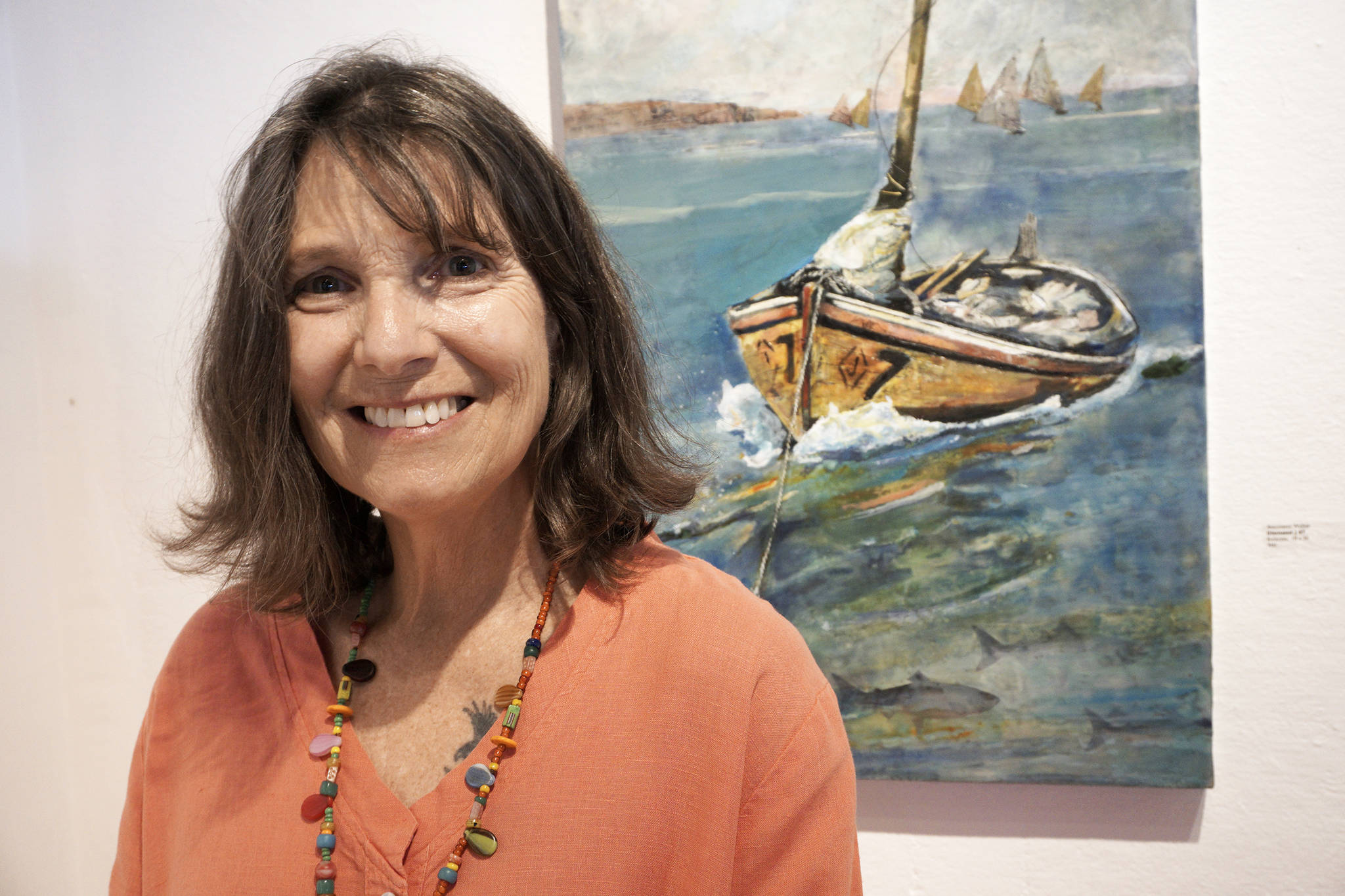 Antoinette Walker poses by one of her encaustic paintings, “Diamond #7,” at the First Friday opening of her exhibit on July 5 at Bunnell Street Arts Center in Homer. (Photo by Michael Armstrong/Homer News)
