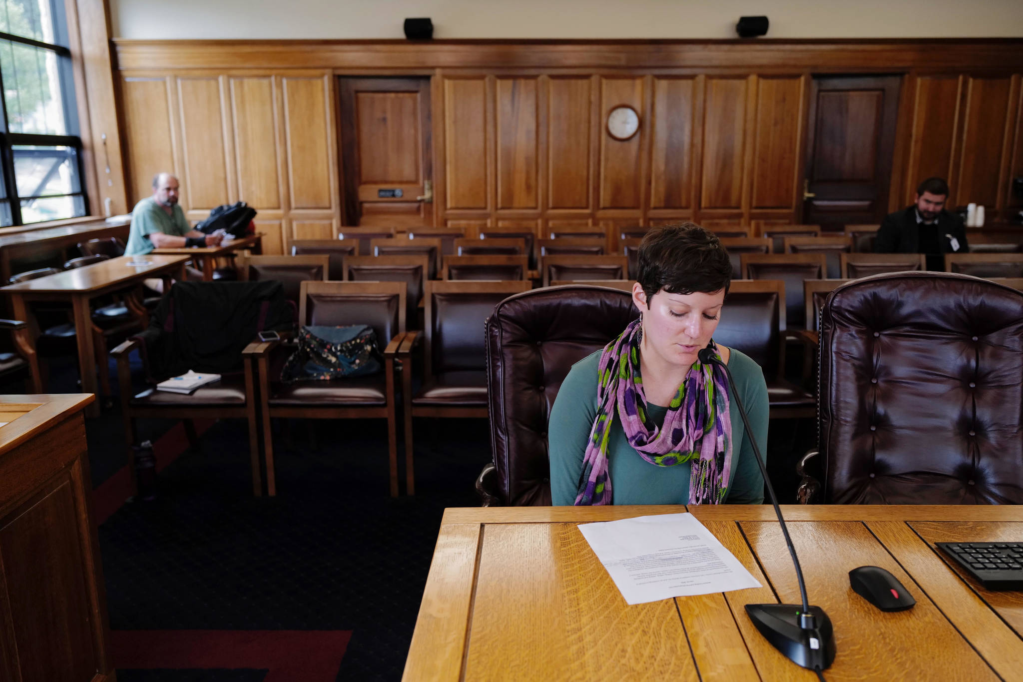 Michael Penn | Juneau Empire                                Alyson Currey gives testimony on HB 2001 in the House Finance Committee room as Marc Wheeler, left, waits his turn at the Capitol on Tuesday, July 16. The committee is meeting in Wasilla and taking testimony telephonically from around the state.