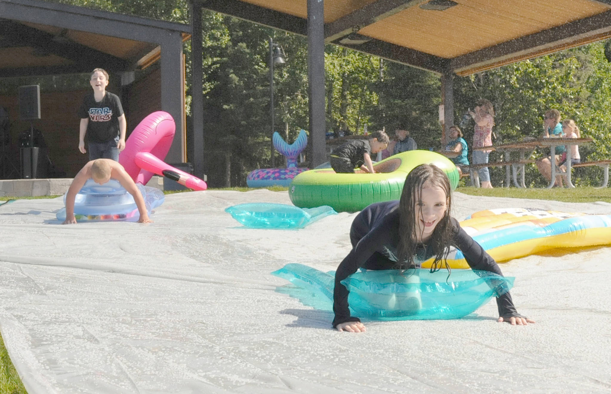 Elizabeth Earl / Peninsula Clarion                                 Kids slip and slide at the Disability Pride event at Soldotna Creek Park on July 21, 2018, in Soldotna.