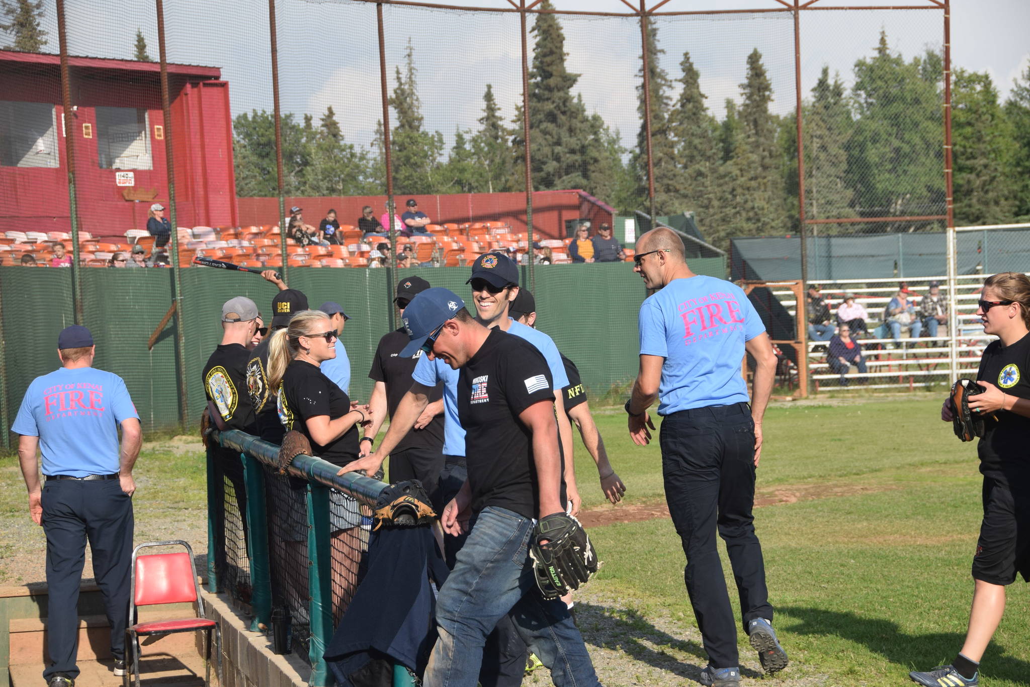 Nikiski and Kenai firefighters head to the dugout at the end of the seventh inning during the third annual Guns and Hoses charity baseball game at Coral Seymour Memorial Park in Kenai, Alaska on July 19, 2019. (Photo by Brian Mazurek/Peninsula Clarion)