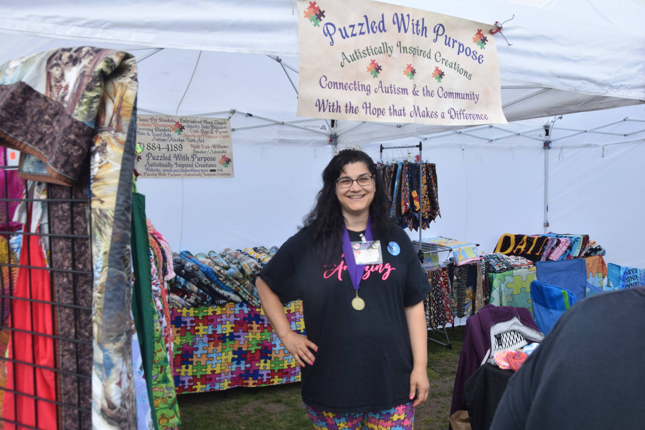 Heidi Lieb-Williams poses in front of her vendor booth during the 2019 Disability Pride Celebration in Soldotna Creek Park on July 20, 2019. (Photo by Brian Mazurek/Peninsula Clarion)