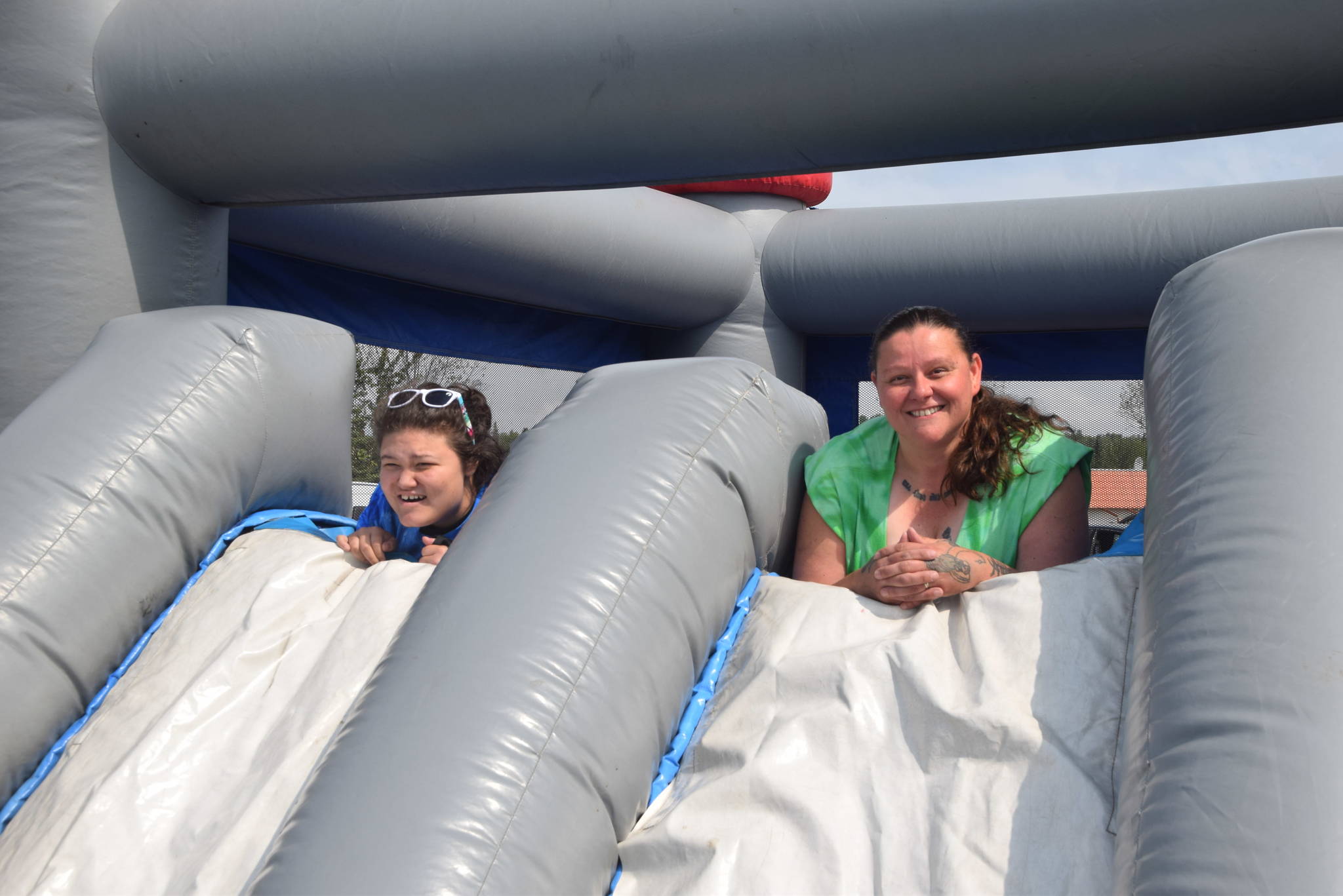 Jordan Tackett, left, and Nikki Marcano, right take a break from the bounce house to pose for a photo during the 2019 Disability Pride Celebration in Soldotna Creek Park on July 20, 2019. (Photo by Brian Mazurek/Peninsula Clarion)