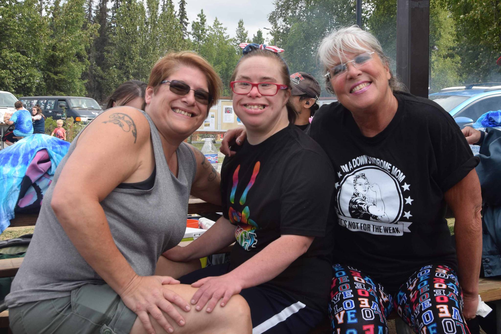 From left, Dee Roddis, Michelle Castro and Sybille Castro-Curry smile for the camera during the 2019 Disability Pride Celebration in Soldotna Creek Park on July 20, 2019. (Photo by Brian Mazurek/Peninsula Clarion)