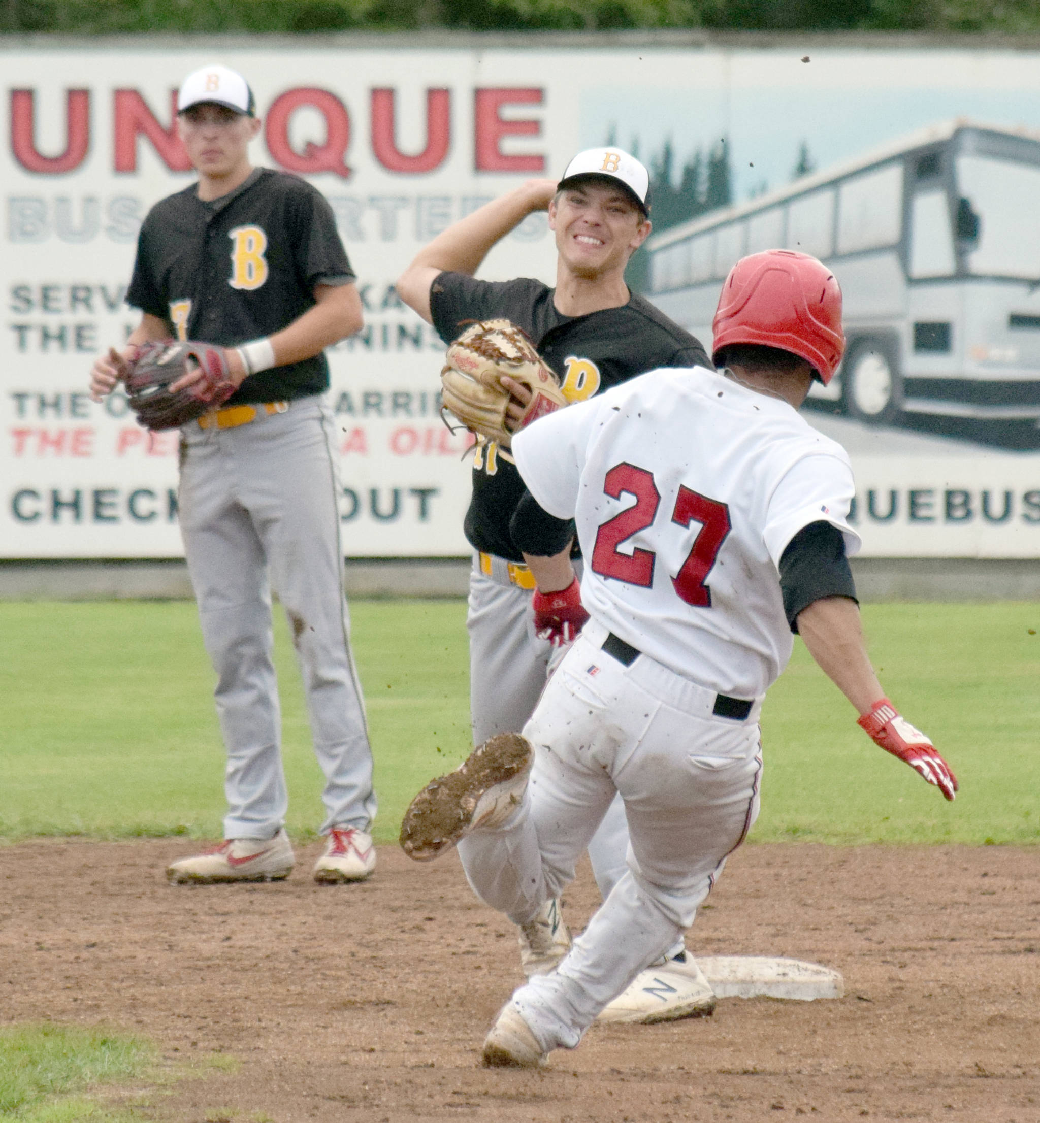 Anchorage Bucs second baseman Spencer Long turns a double play in front of Peninsula Oilers’ Jonathan Villa on Friday at Coral Seymour Memorial Park in Kenai. (Photo by Jeff Helminiak/Peninsula Clarion)