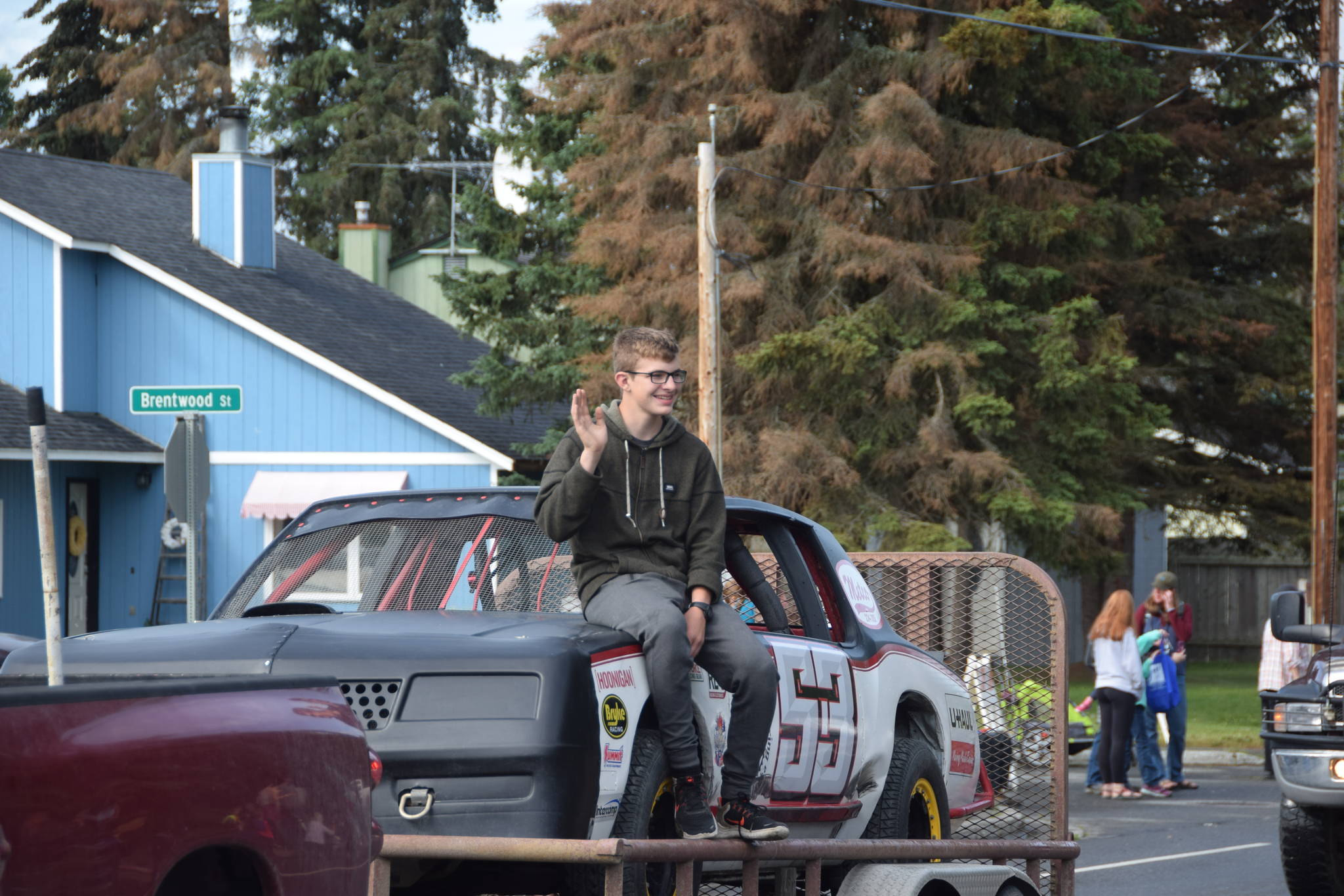 A volunteer from Twin City Raceway waves to the crowd during Soldotna’s Progress Day Parade in Soldotna, Alaska on July 27, 2019. (Photo by Brian Mazurek/Peninsula Clarion)
